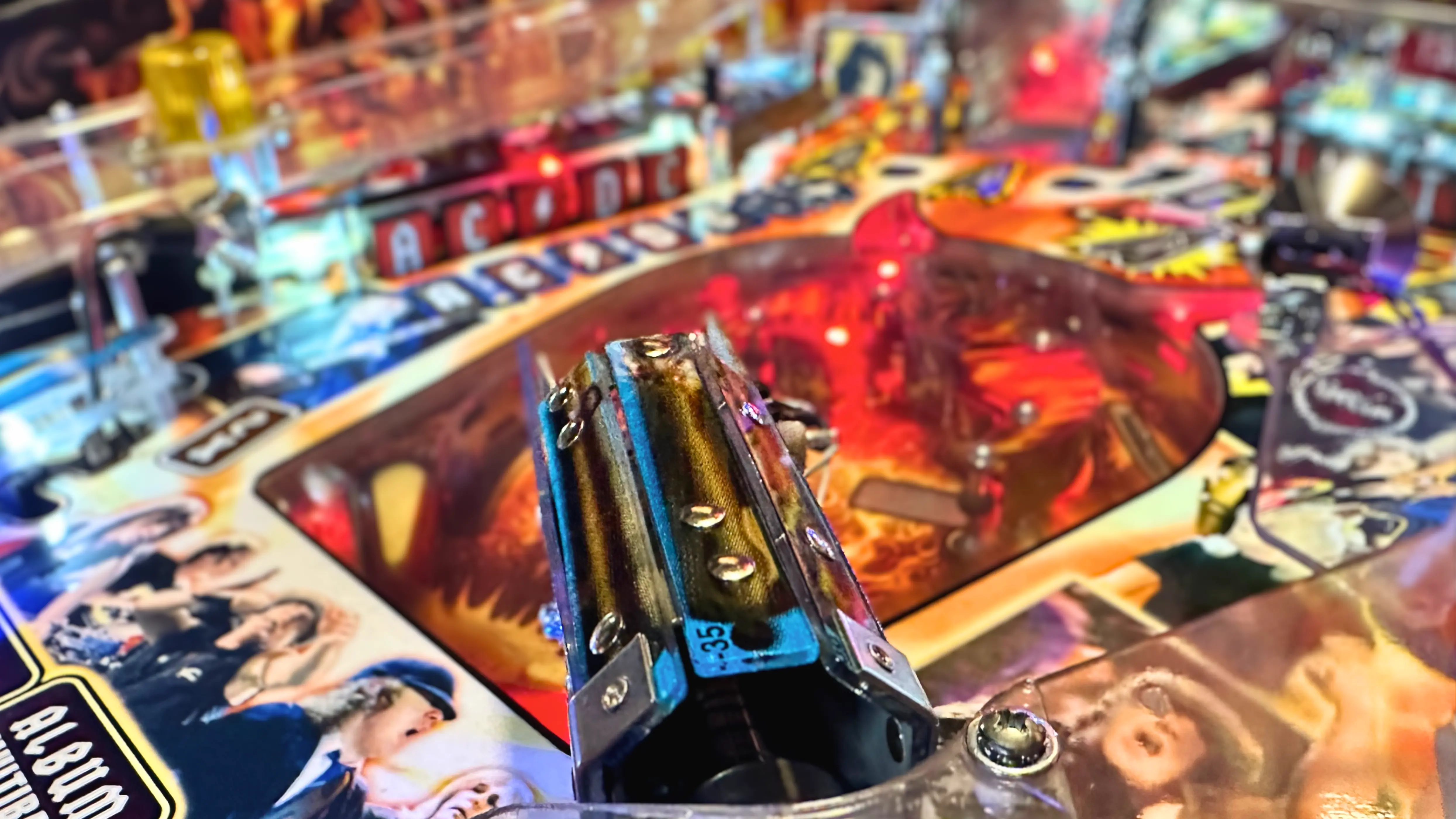 Pinball machine with colorful playfield and metallic flipper mechanism