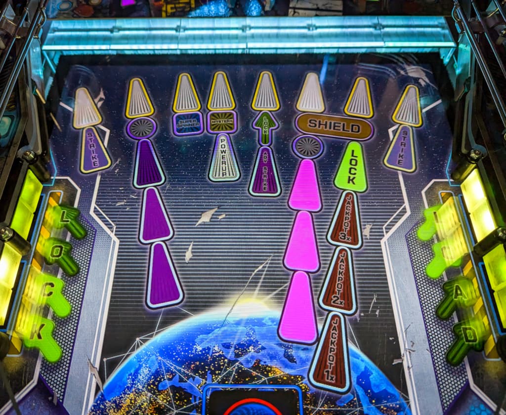 Colorful pinball machine playfield with earth and glowing targets