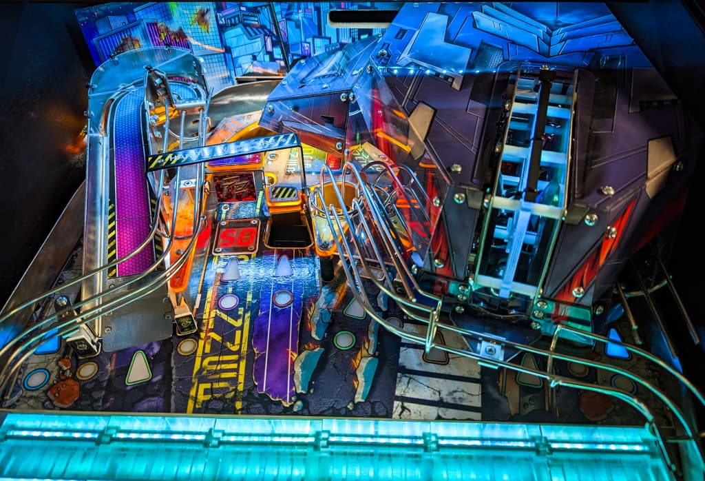 Colorful pinball machine interior with intricate mechanical components and lights