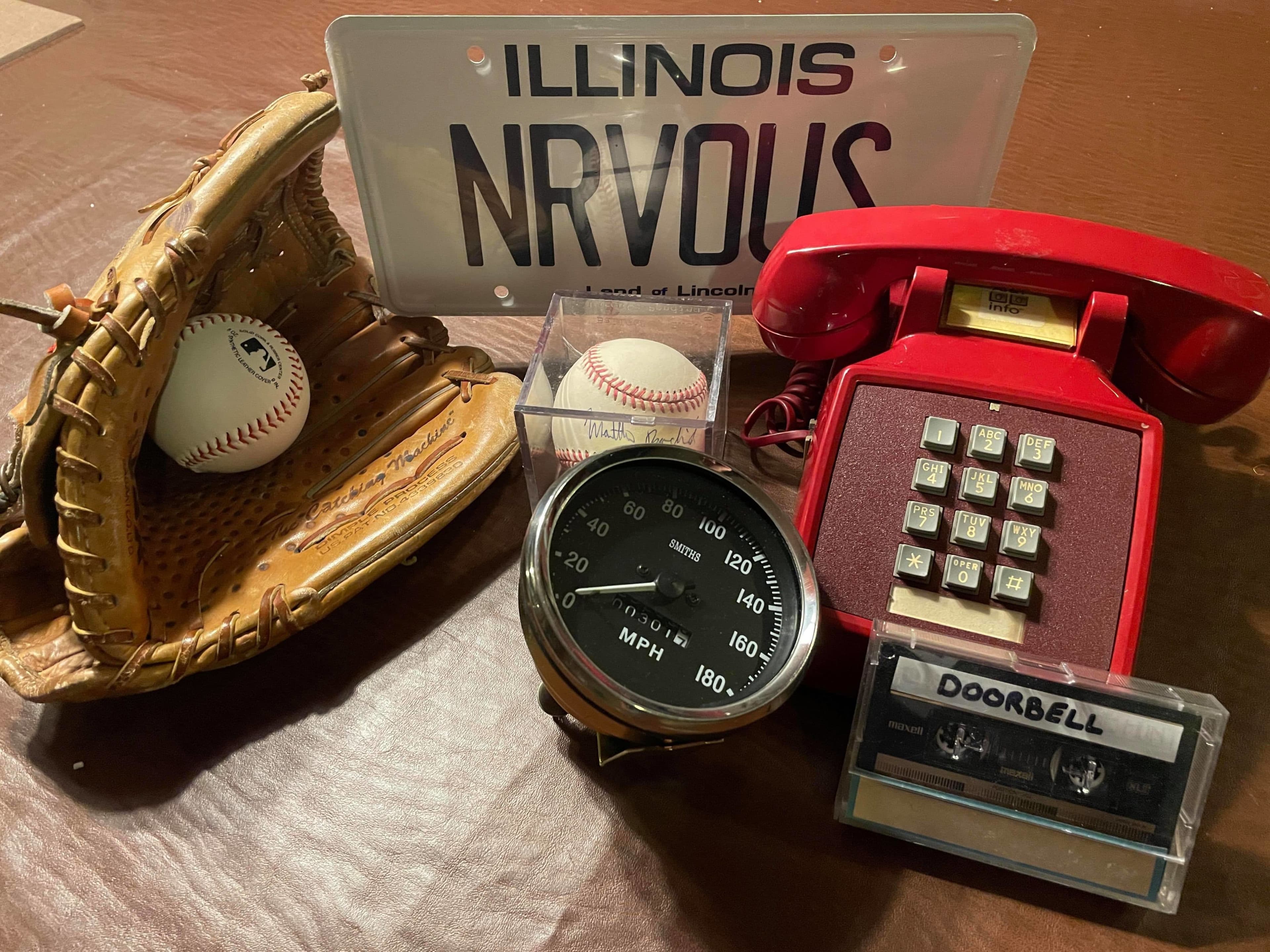Vintage items including baseball glove, speedometer, license plate, phone