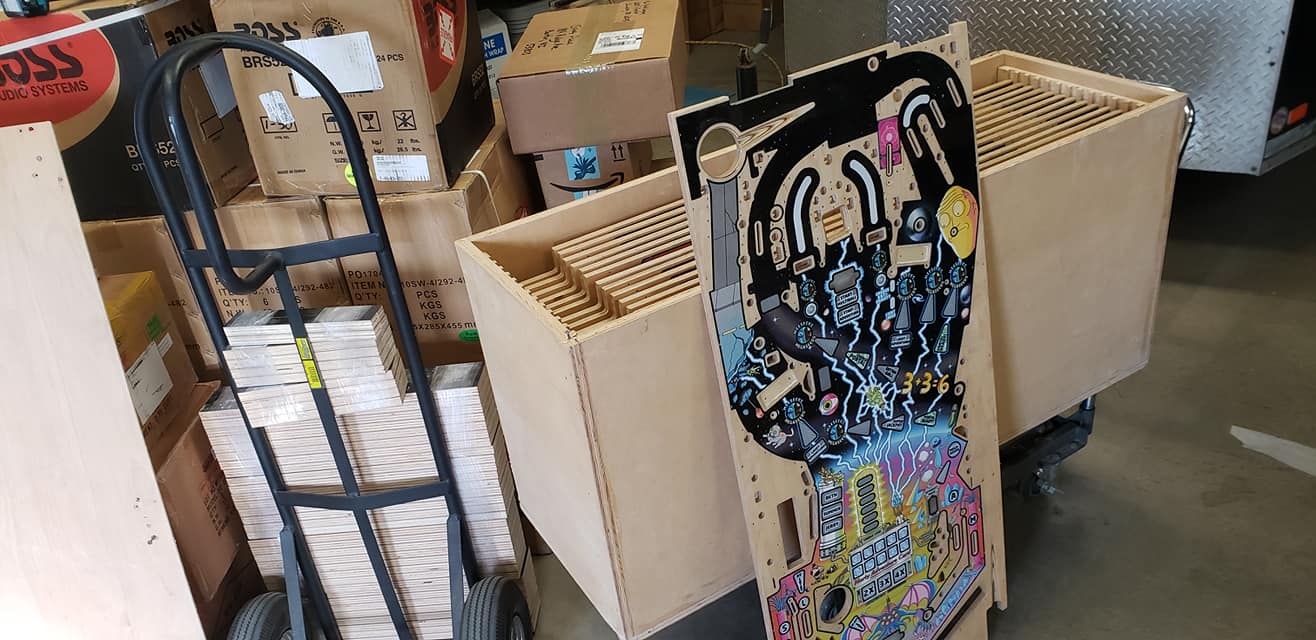 Colorful electronic circuit board design next to cardboard boxes and dolly