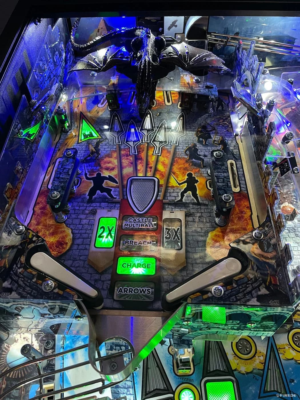 Detailed fantasy-themed pinball machine with dragon, castle, and glowing green elements