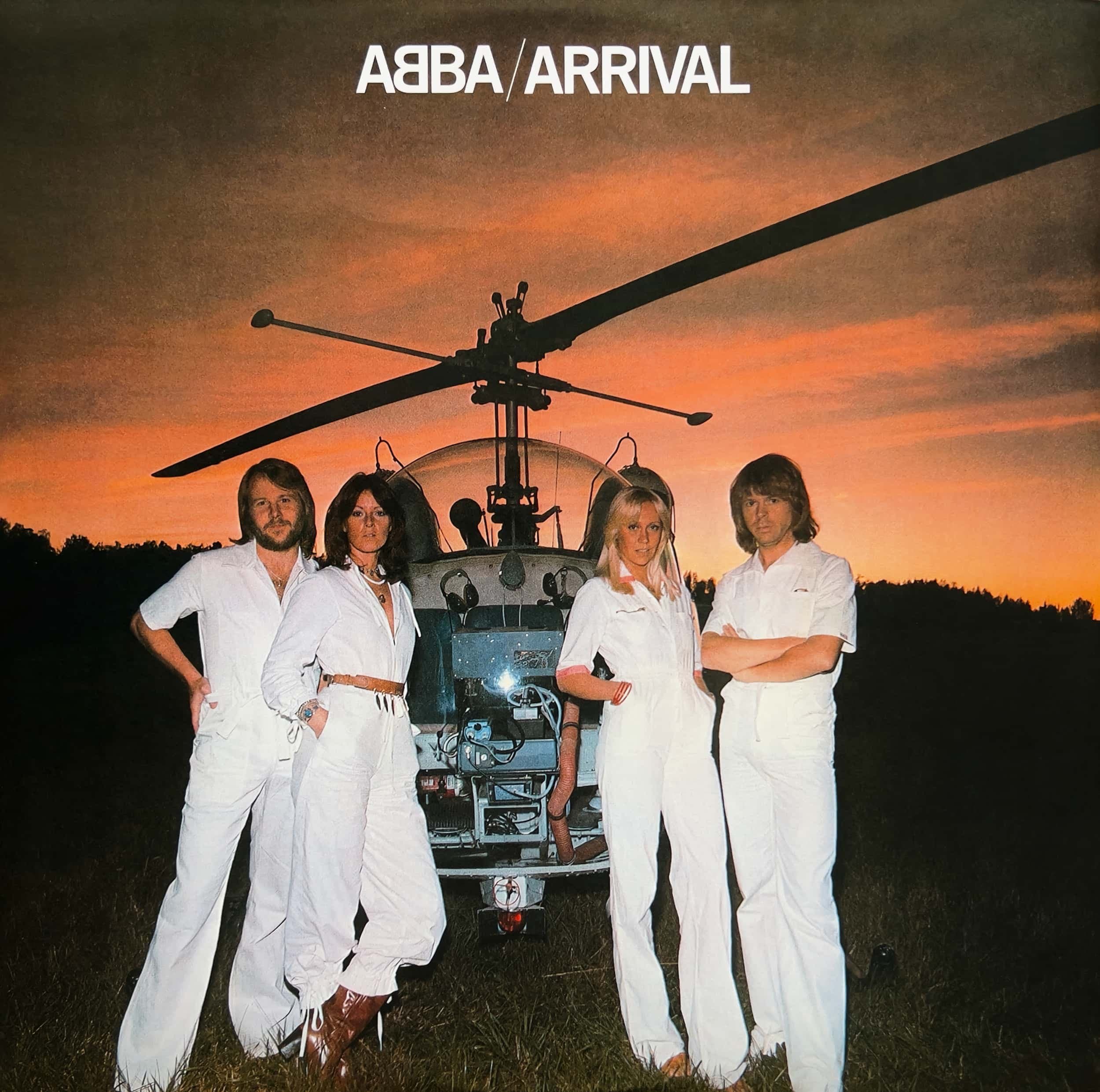 ABBA in white outfits posing with helicopter at sunset