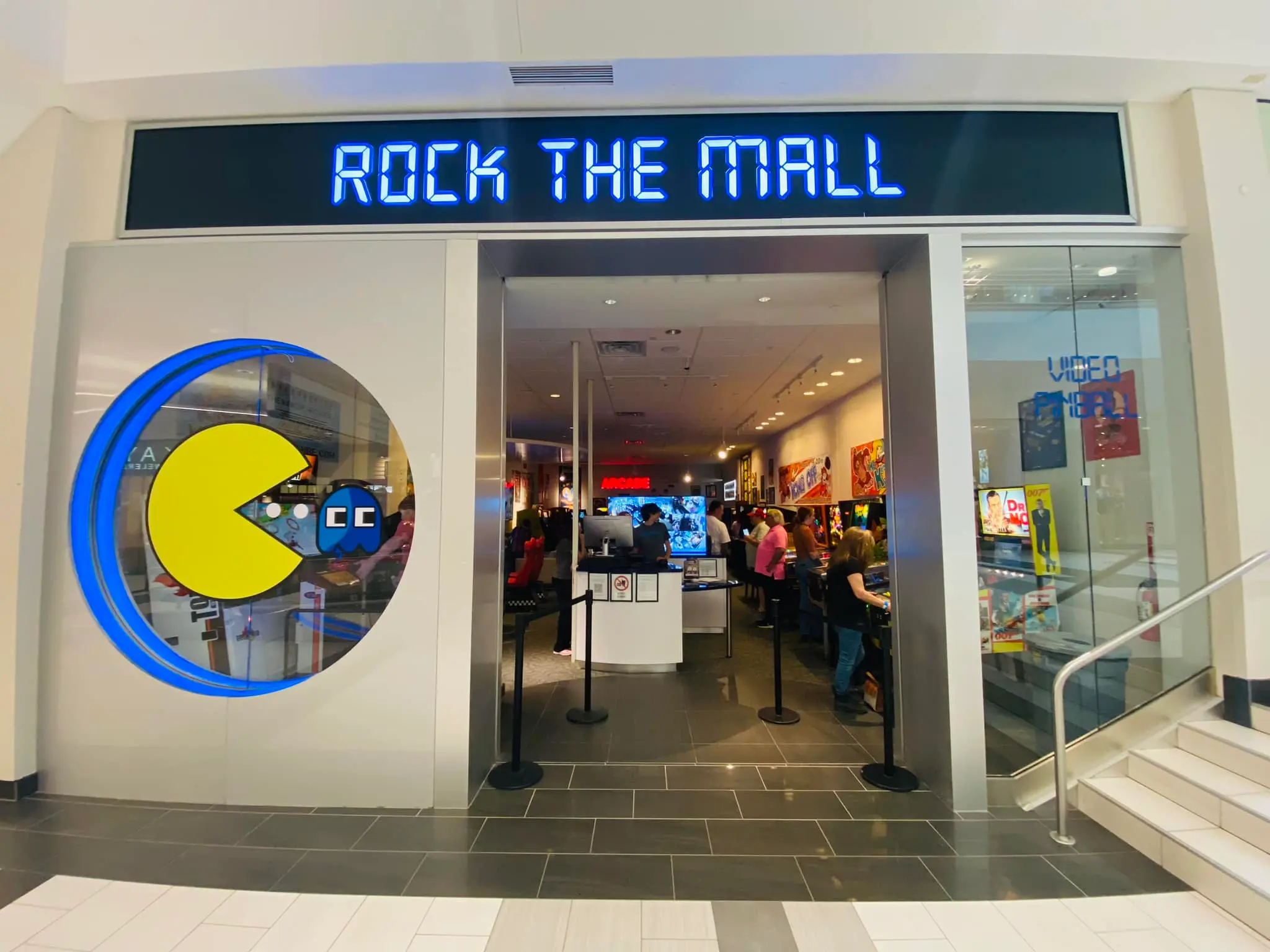 Rock the Mall gaming store entrance with Pac-Man logo and blue neon sign