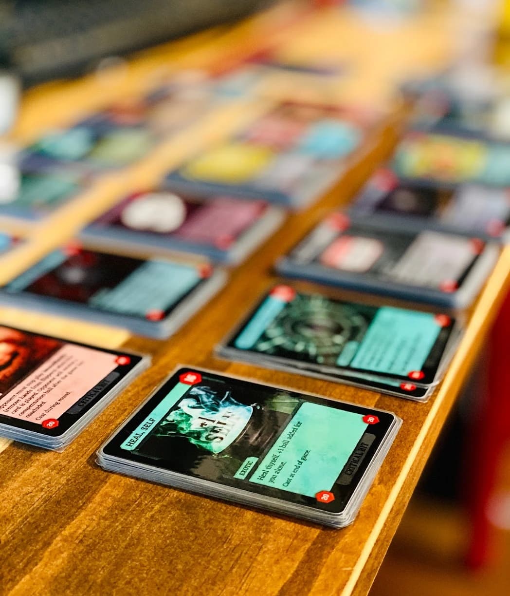 Board game cards scattered on wooden surface with blurred background