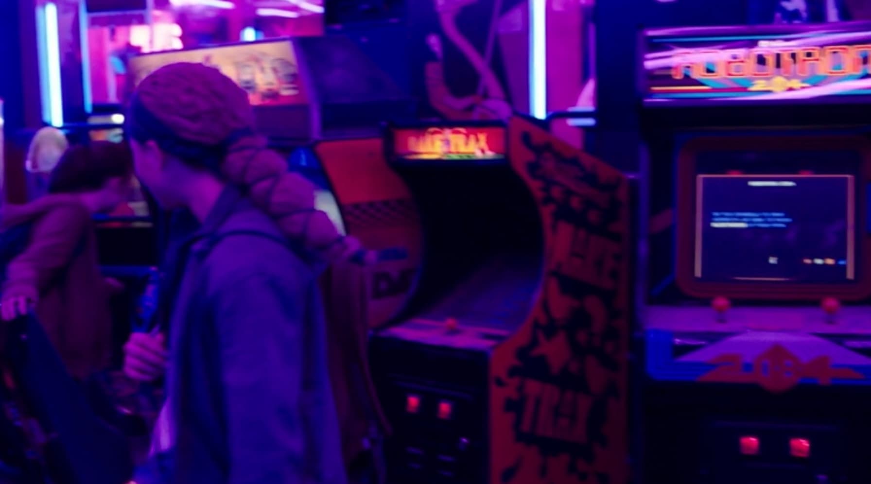 Arcade scene with neon lights and gaming machines in vibrant purple hues