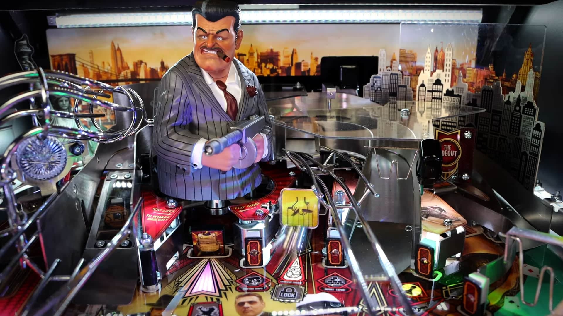 Vintage gangster figurine on colorful pinball machine with city skyline backdrop