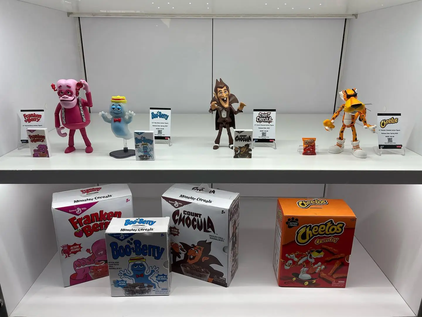 Cartoon mascots of monster-themed cereals displayed with their boxes