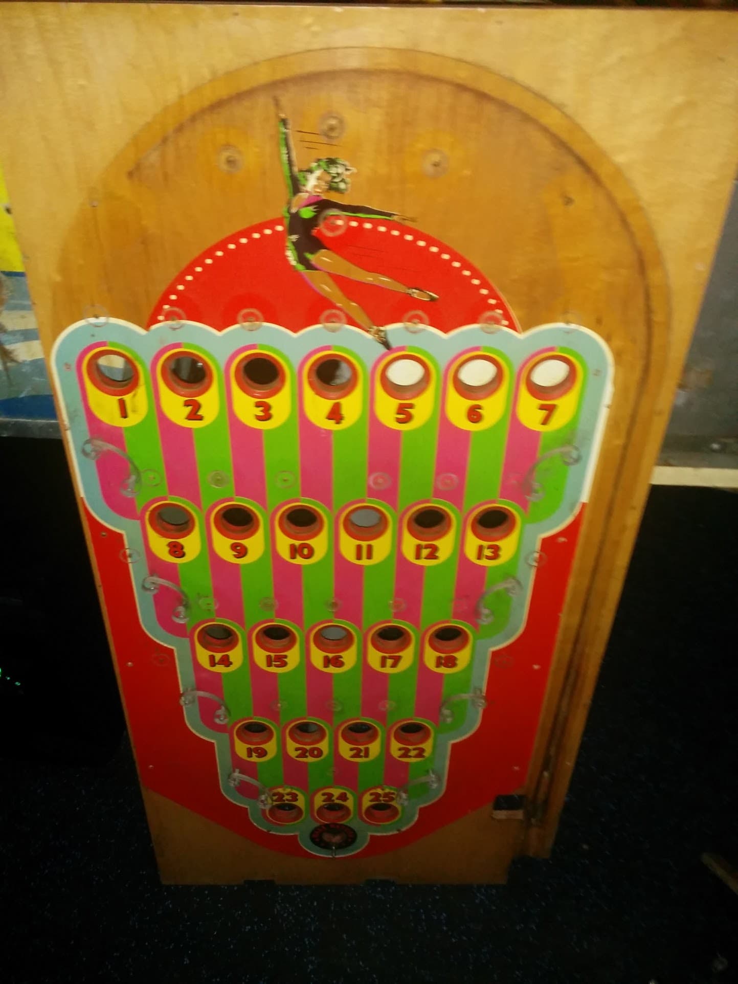 Vintage pinball machine scorecard with colorful numbered holes and figure
