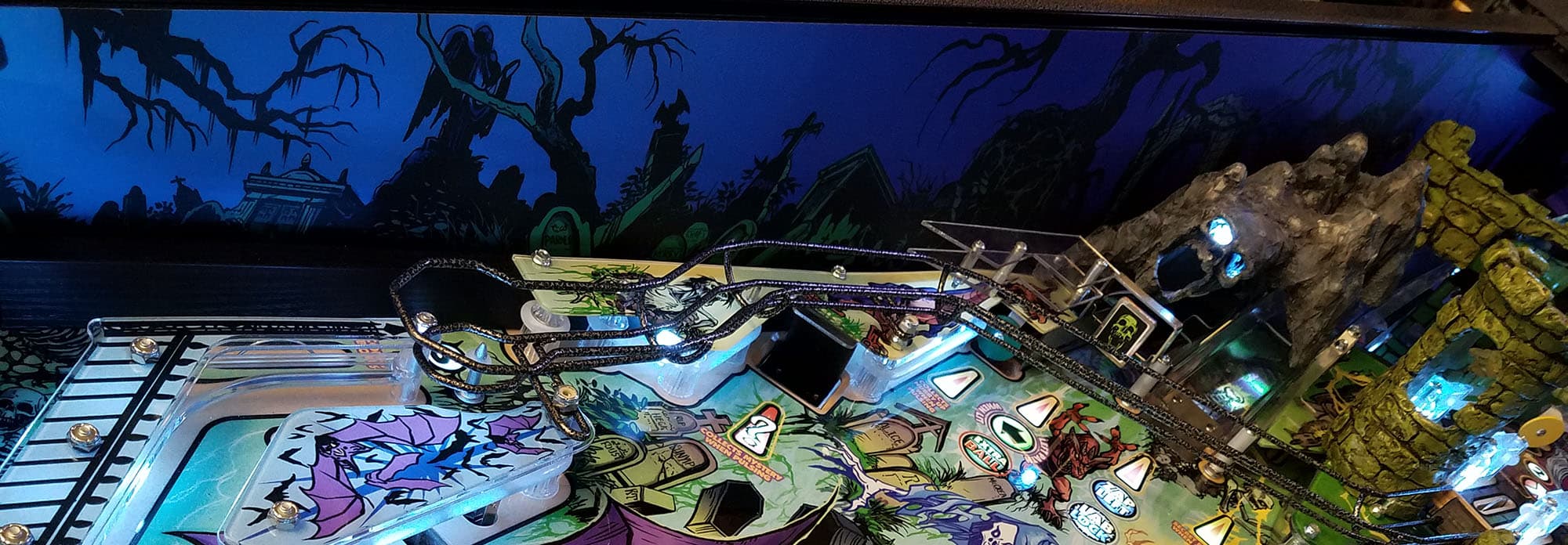 Colorful pinball machine with spooky gothic background and intricate playfield details
