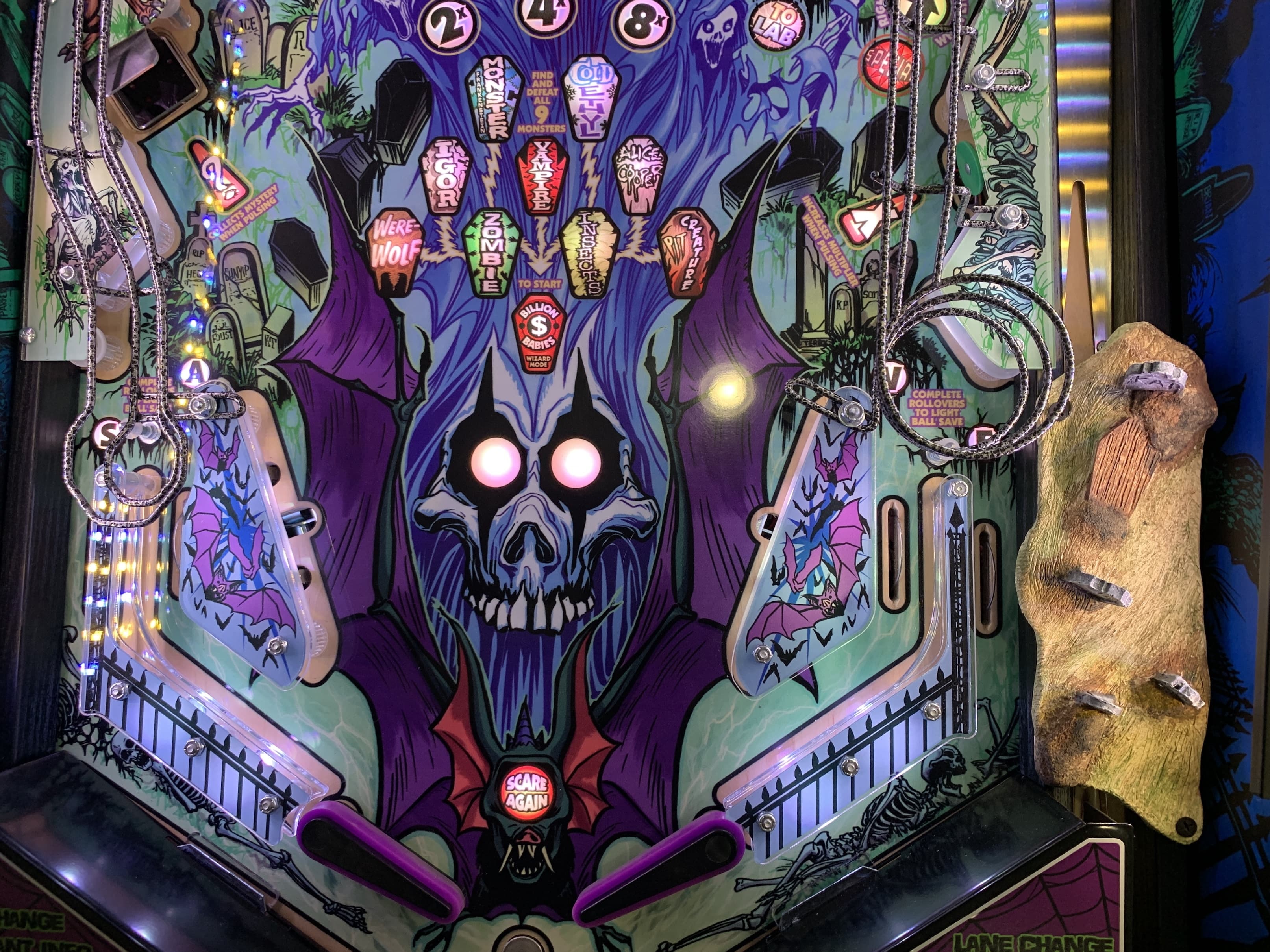 Spooky horror-themed pinball machine with skull, bats, and glowing elements