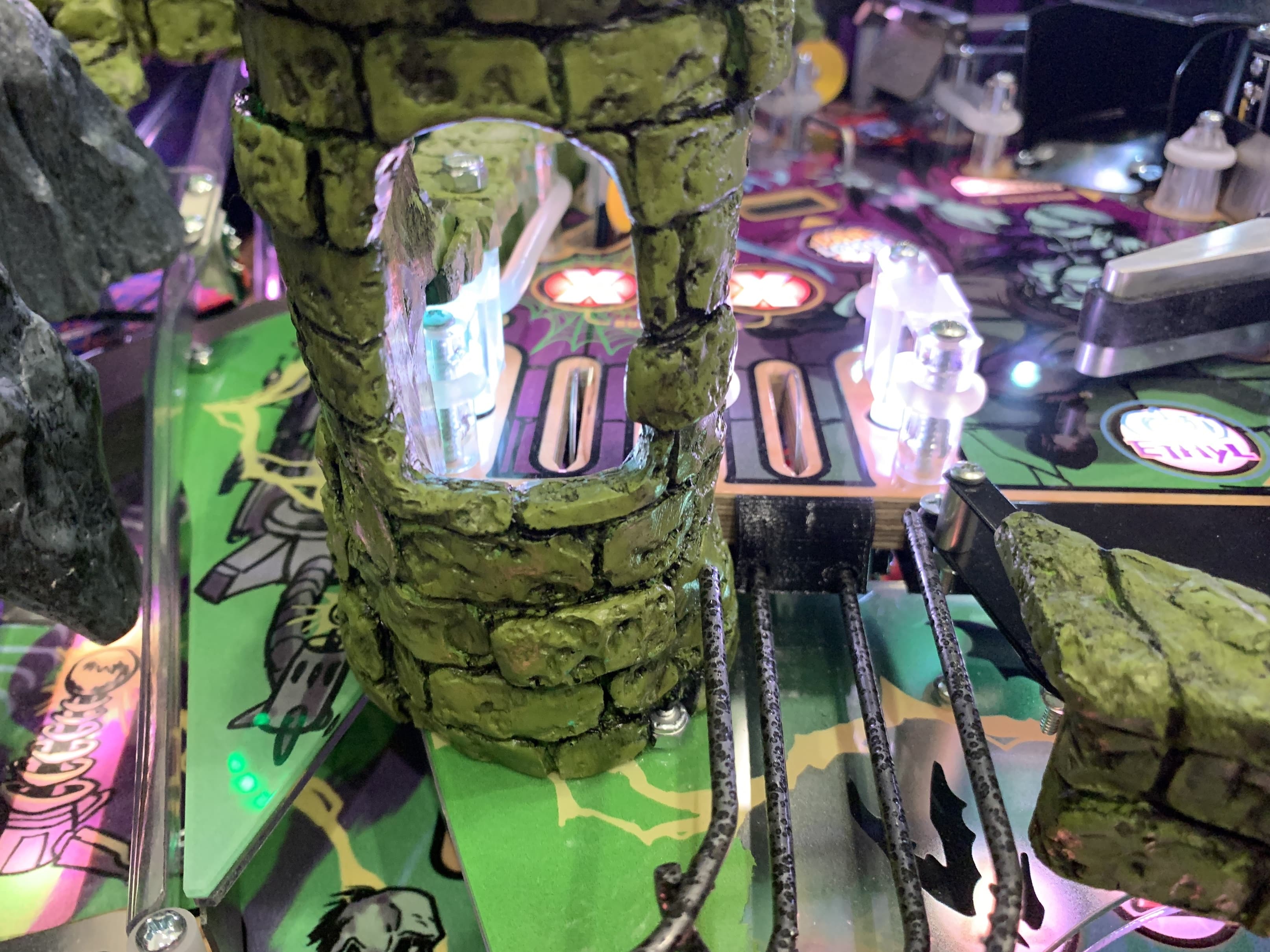 Pinball machine with mossy stone-like pillars and glowing crystal elements