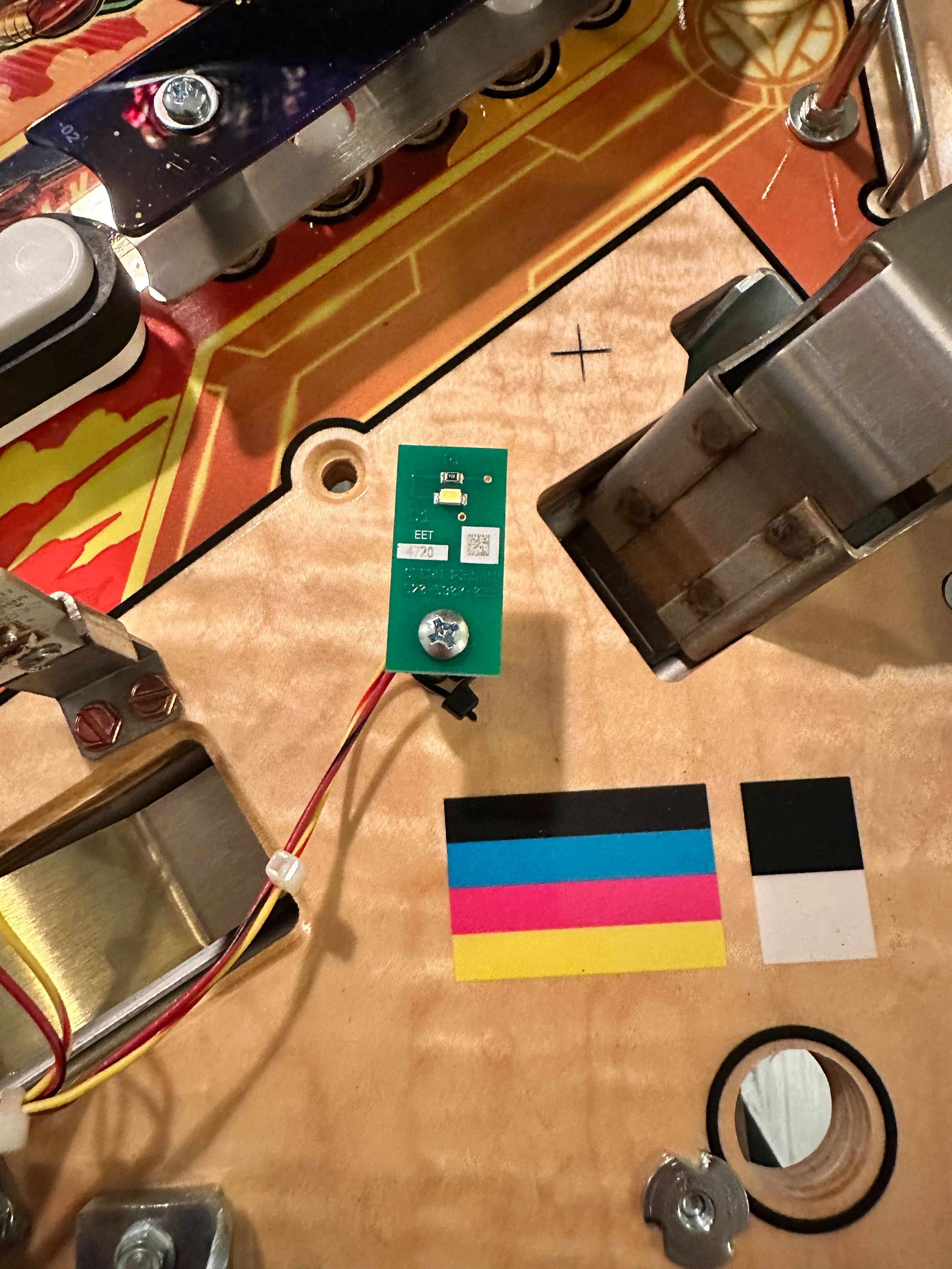 Electronic circuit board with green PCB, wires, and color calibration squares