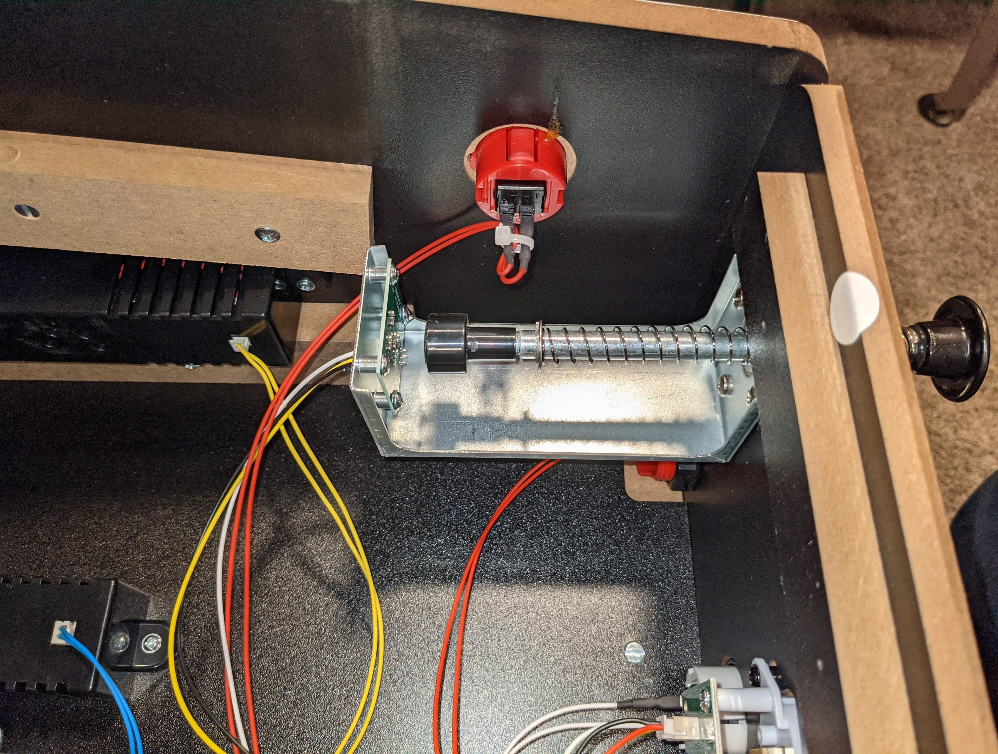 Mechanical device with red button, metal components, and colorful wiring