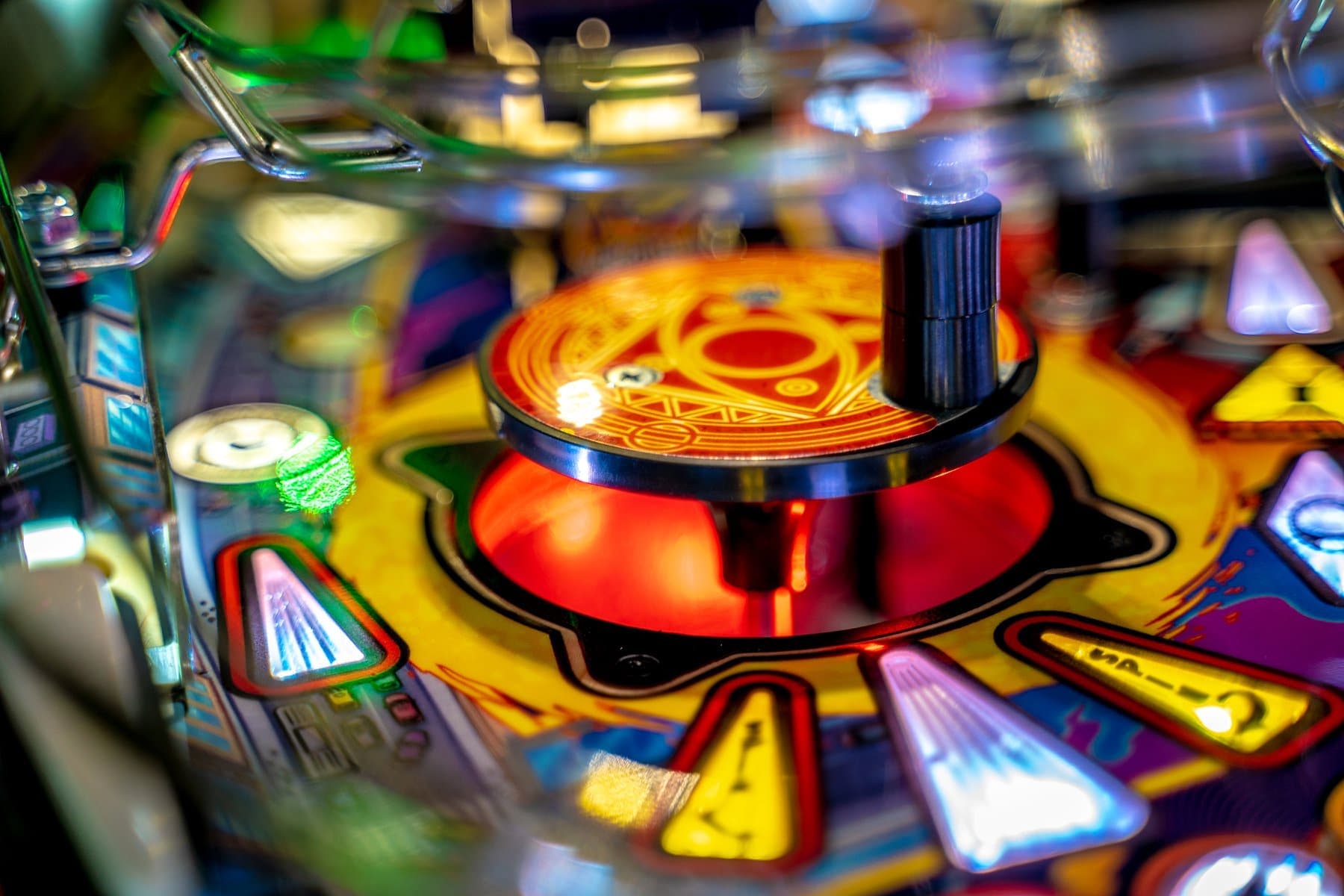 Close-up of colorful pinball machine with vibrant lights and spinning elements