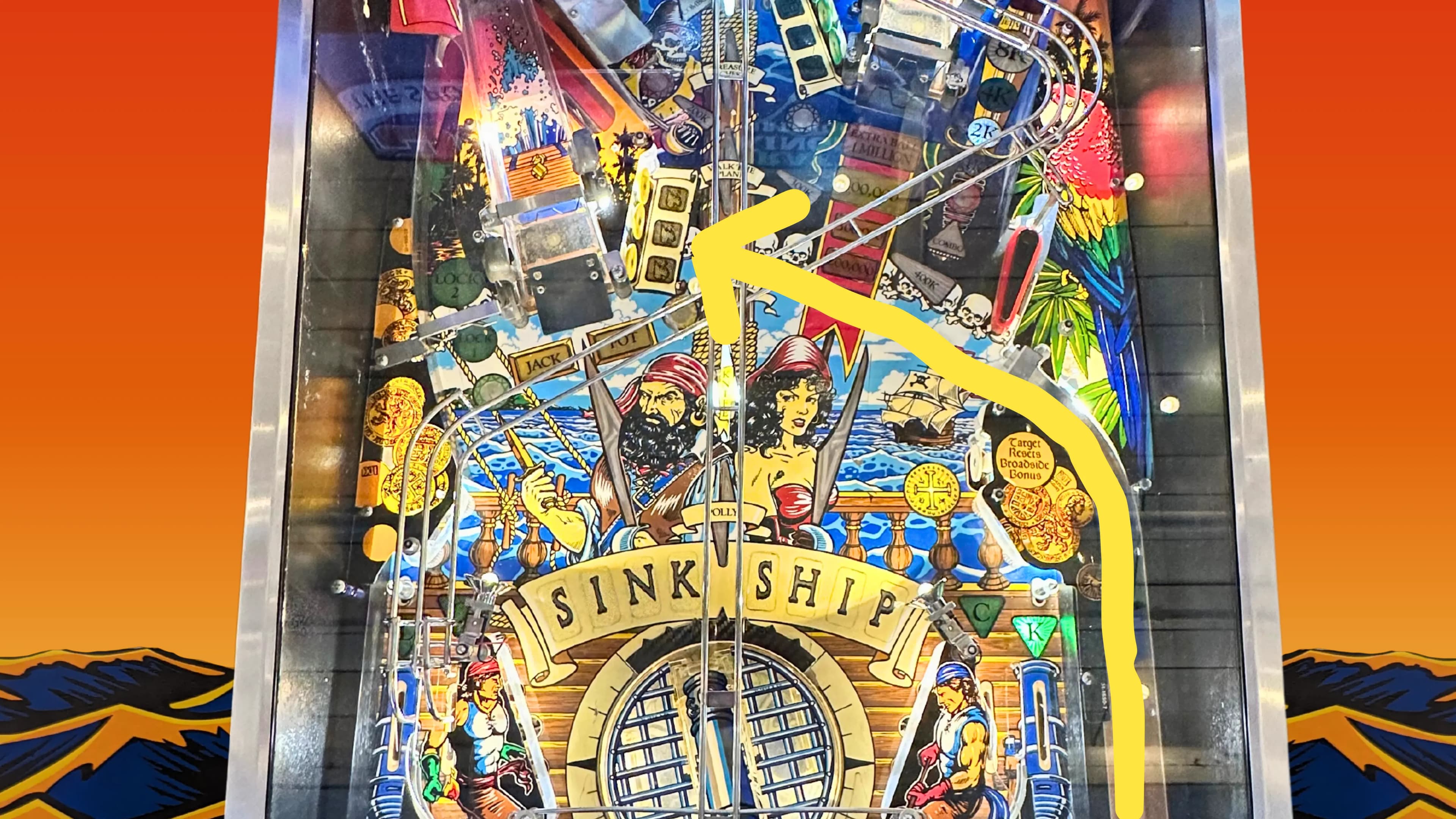 Colorful pinball machine with pirate theme and "Sink Ship" banner