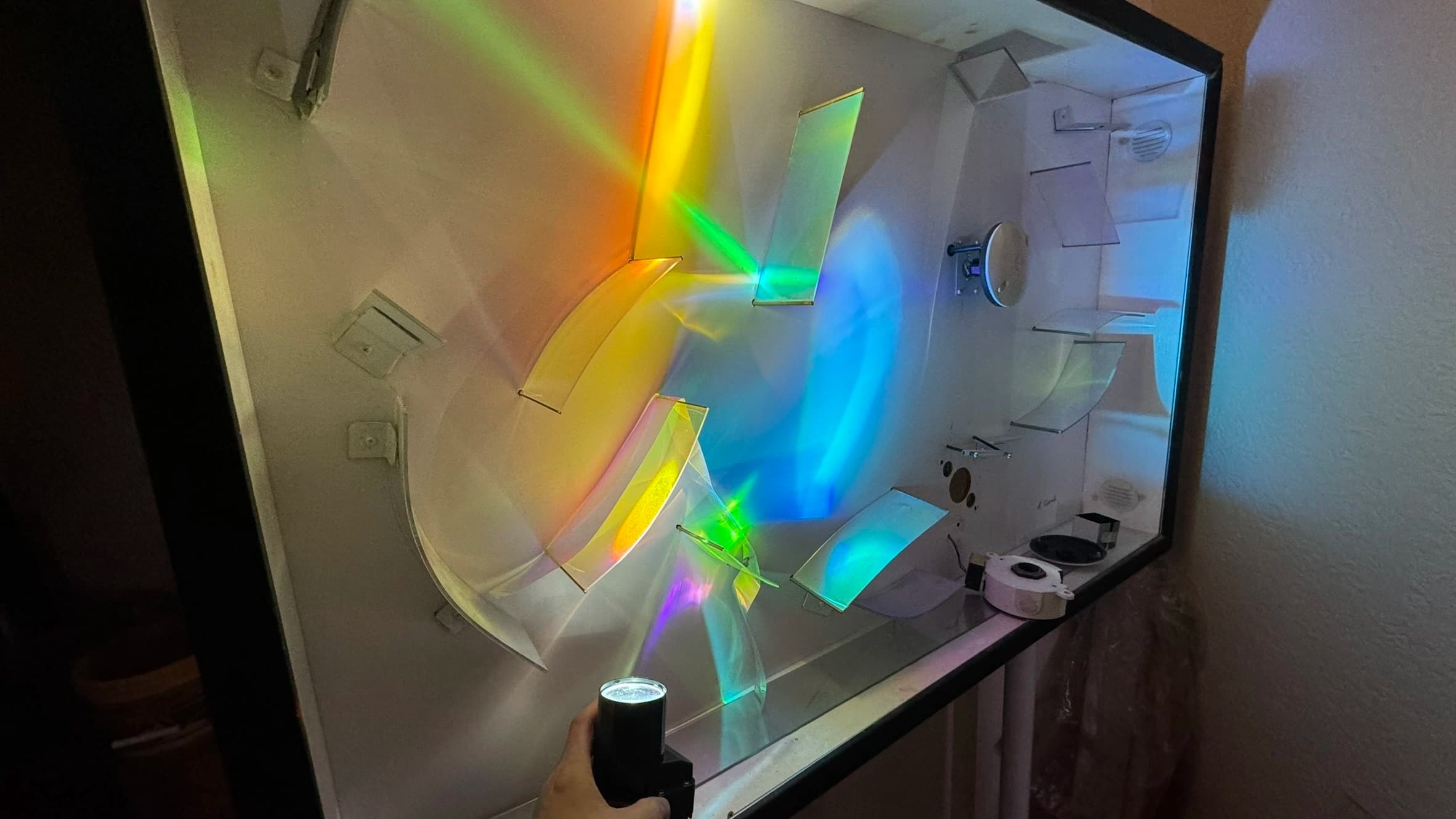 Colorful light refraction through prism creating rainbow effect on wall