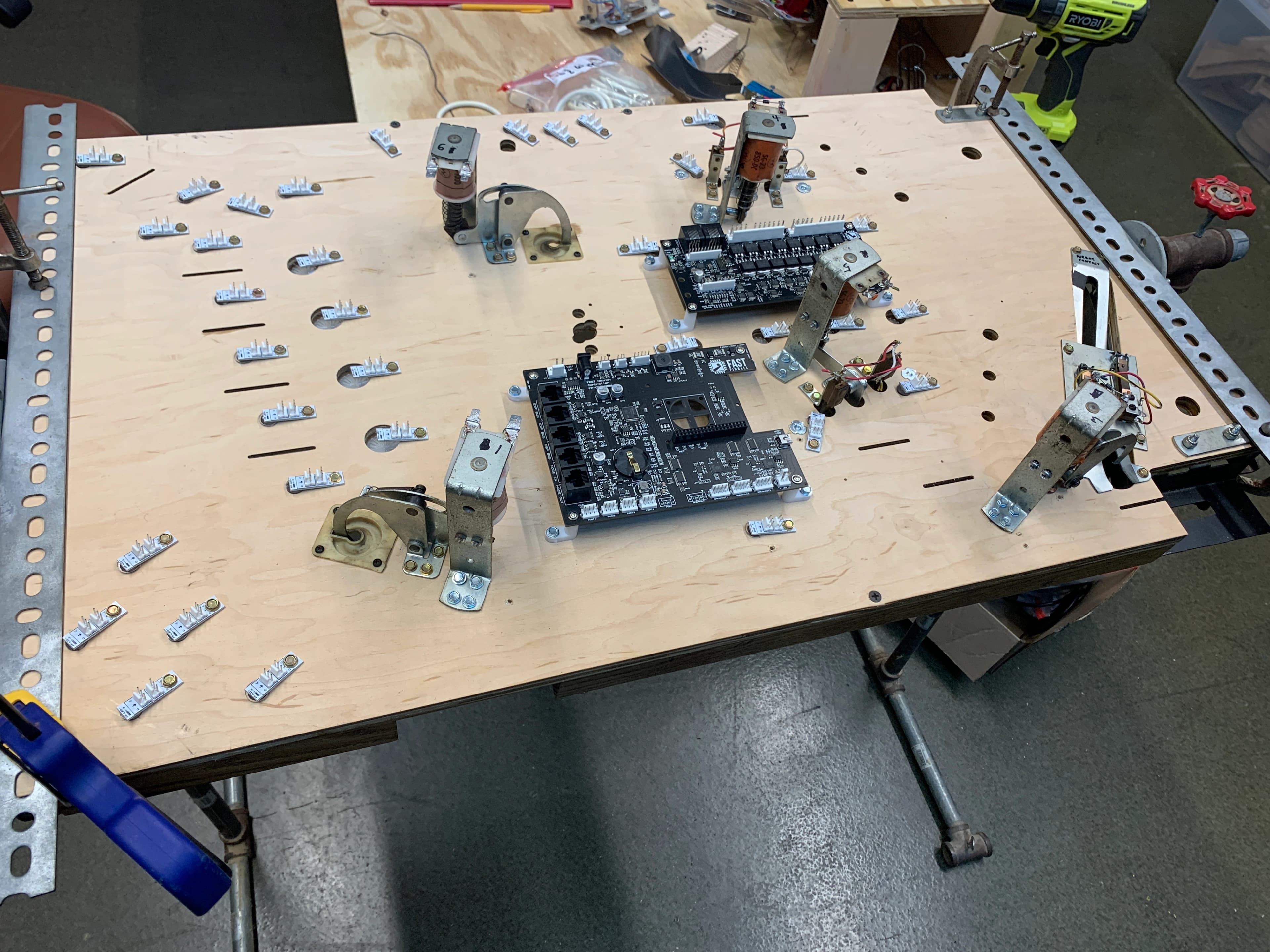 Electronics workbench with circuit boards, motors, and mounting hardware
