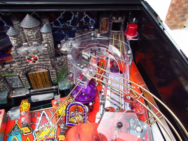 Colorful medieval-themed pinball machine with stone castle and intricate playfield