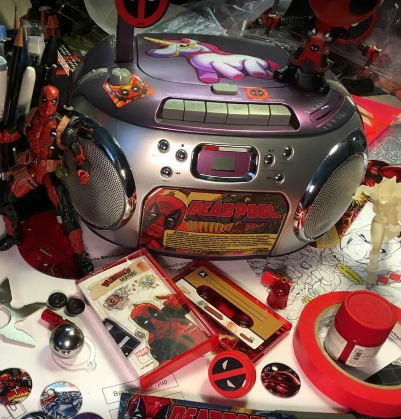 Deadpool-themed boombox surrounded by Marvel collectibles and merchandise