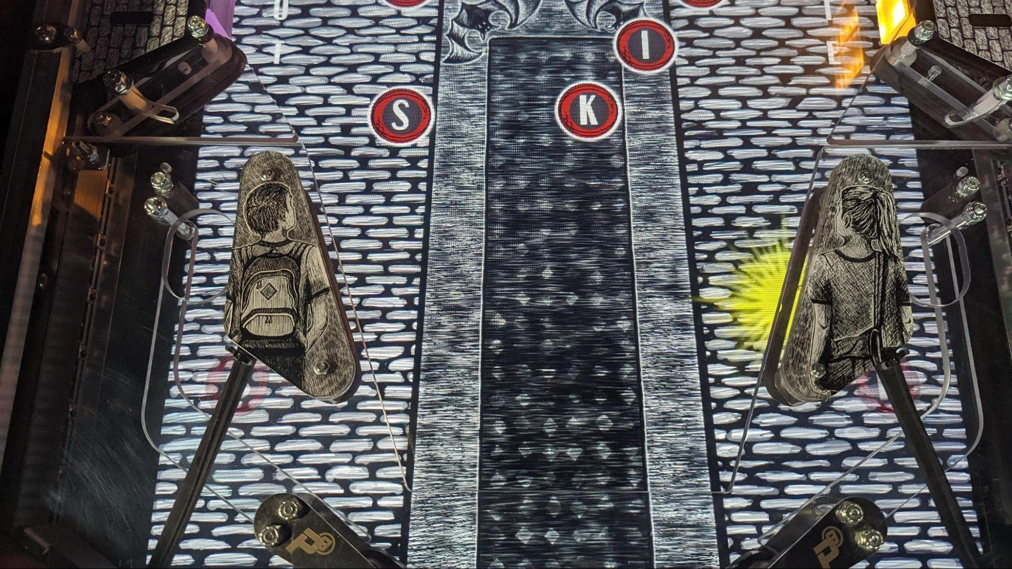 Illustrated figures with letters S, I, K on industrial metallic background