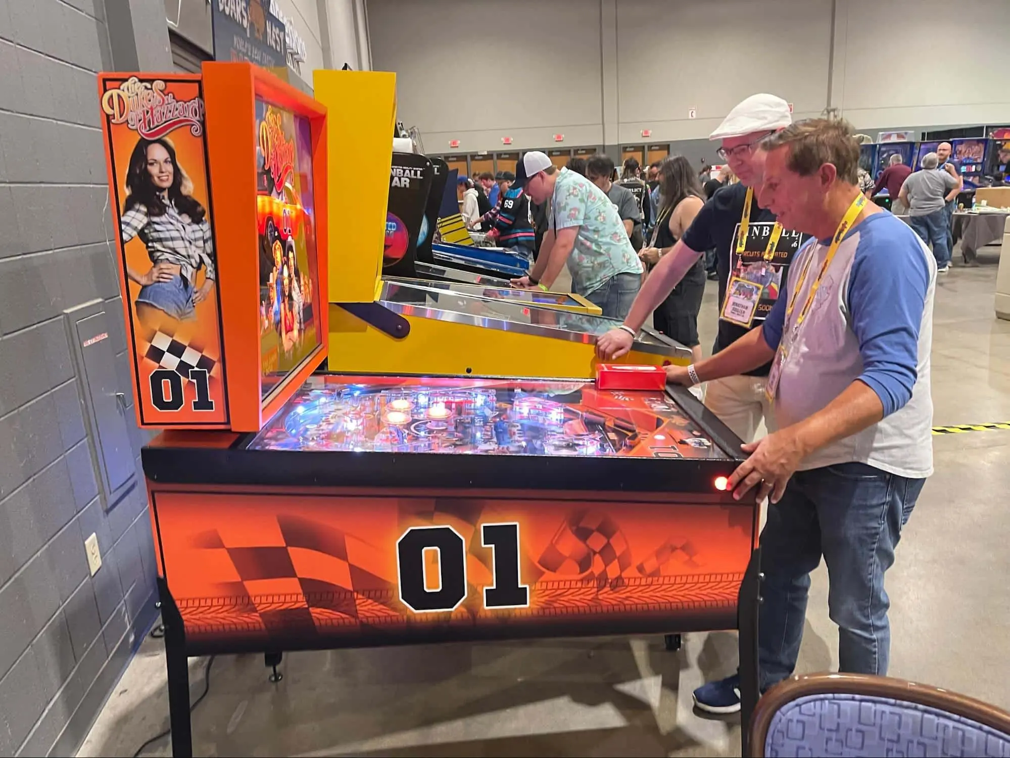 Dukes of Hazzard themed pinball machine at gaming convention with players