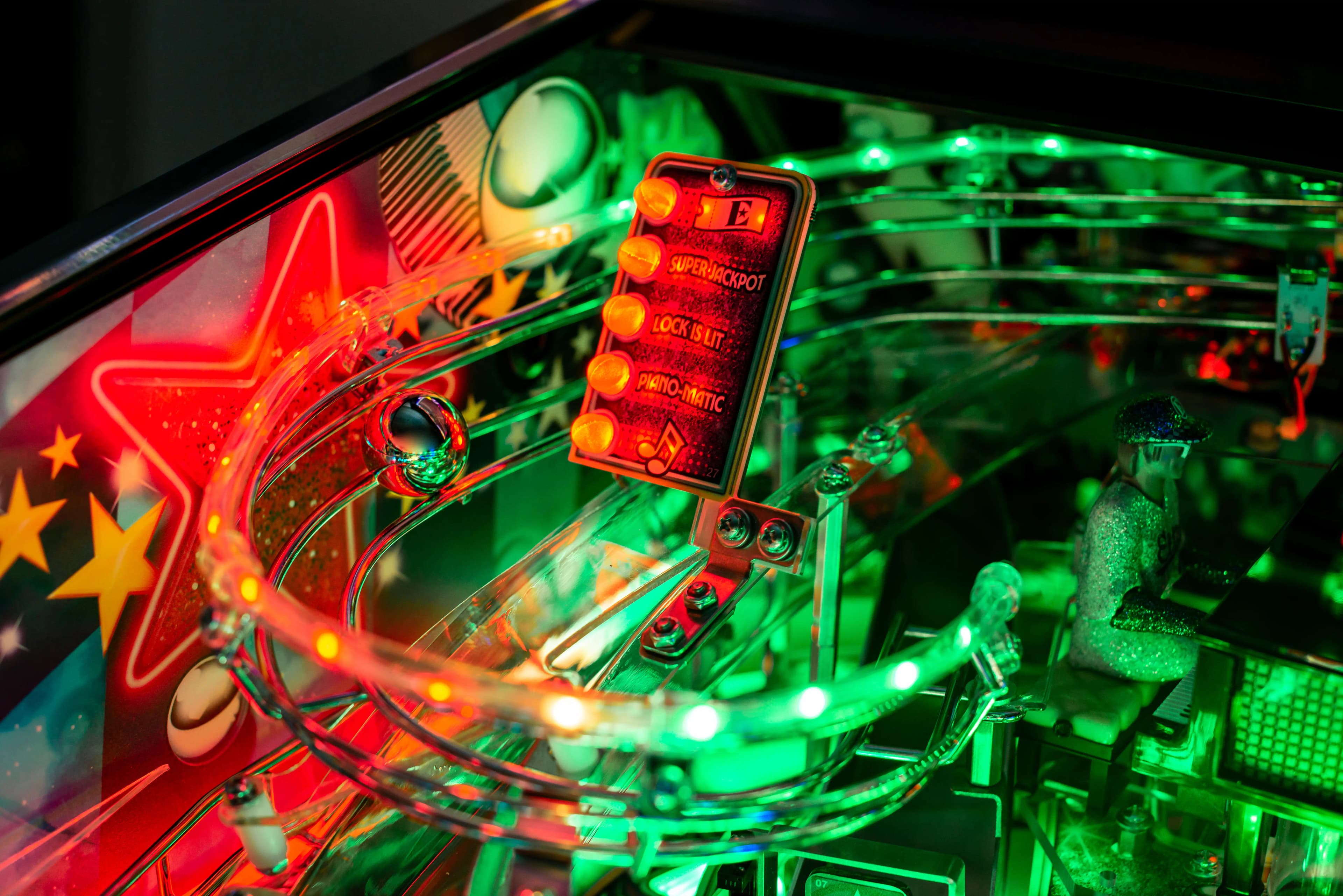 Illuminated pinball machine interior with vibrant red and green lights