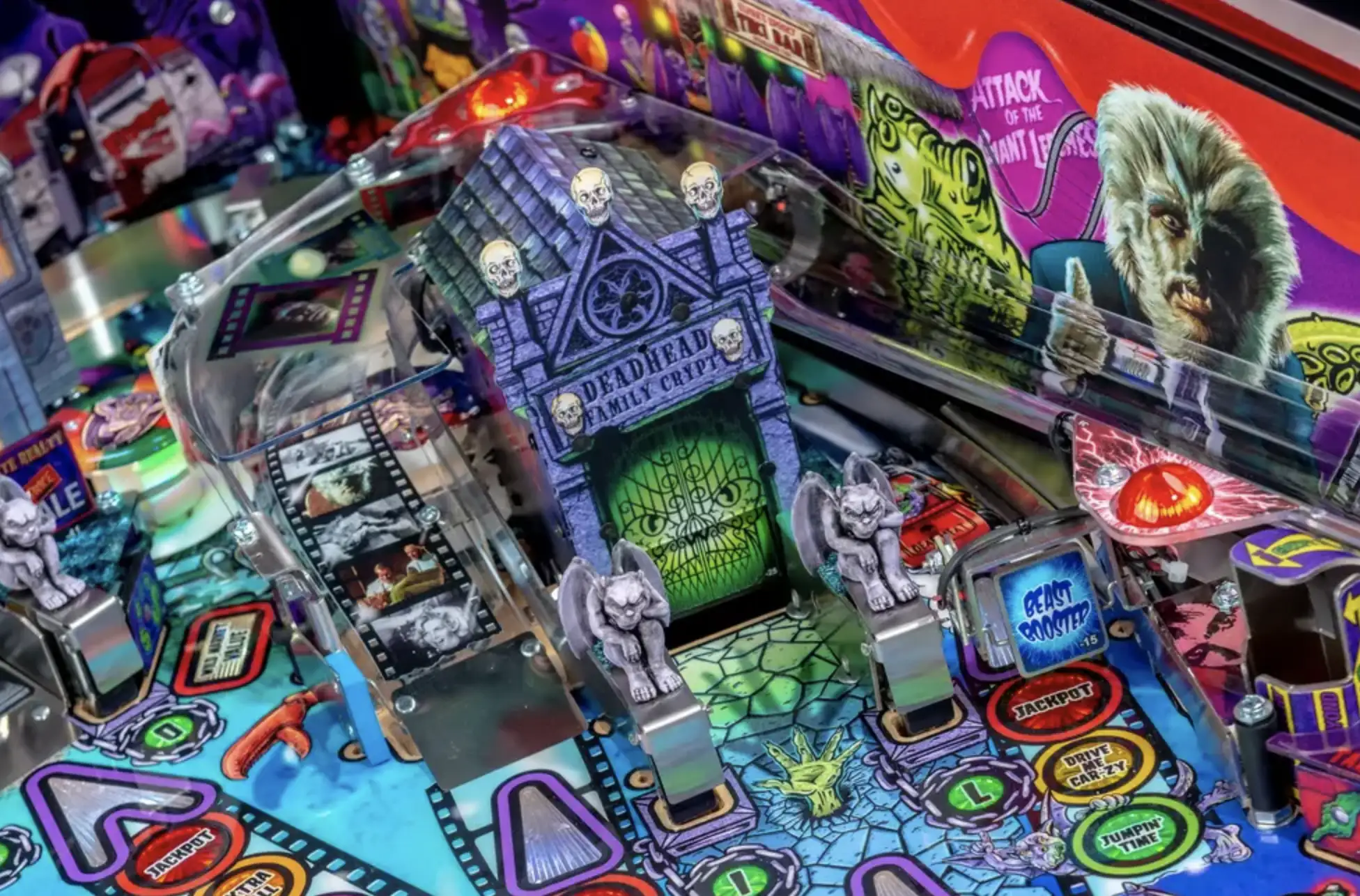 Colorful horror-themed pinball machine with skulls, monsters, and spooky details