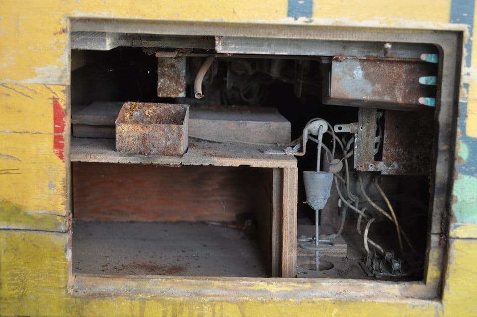 Rusty electrical box with exposed wires and rusted metal components