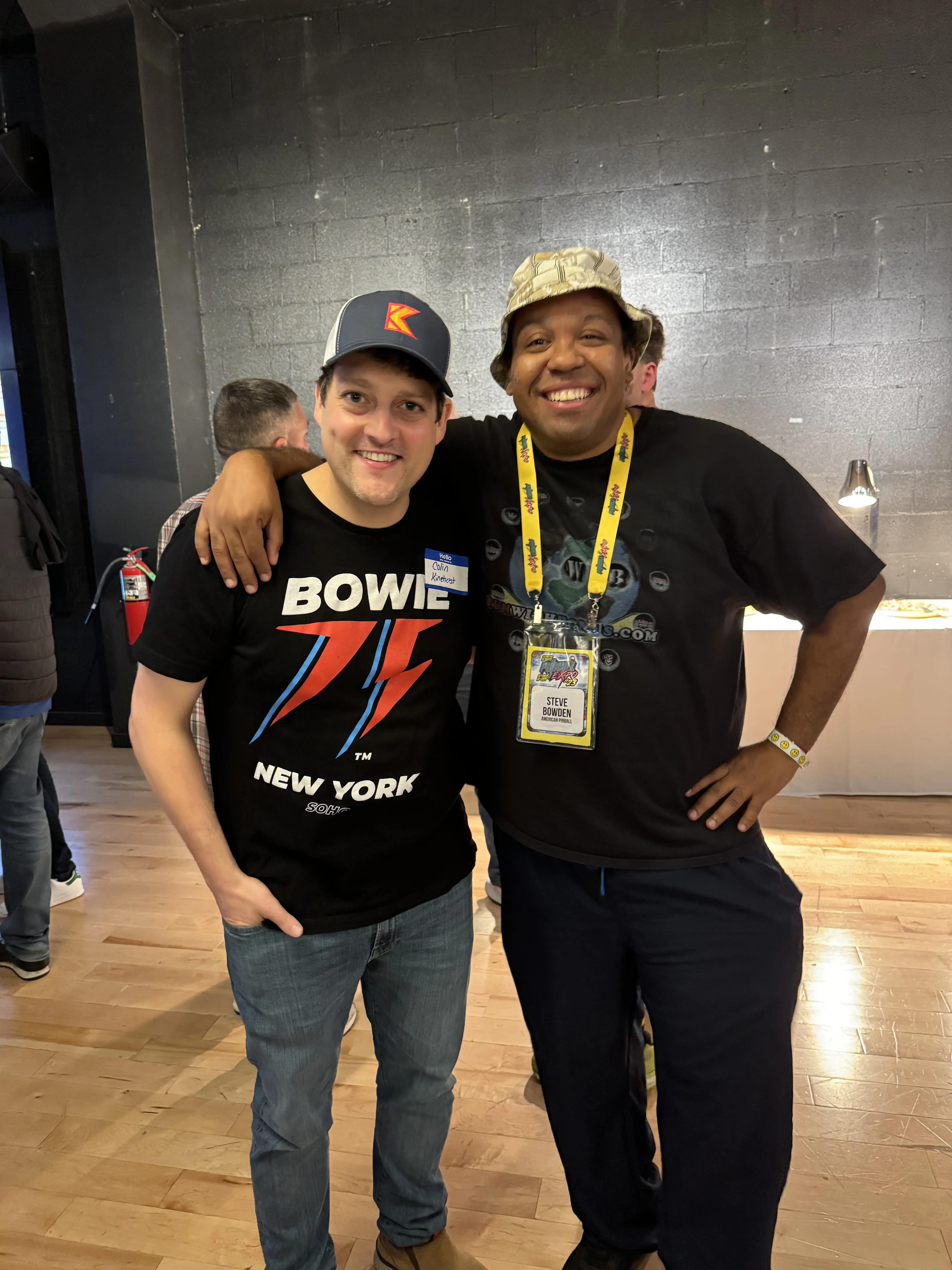 Two smiling colleagues at conference, wearing Bowie and event name tags