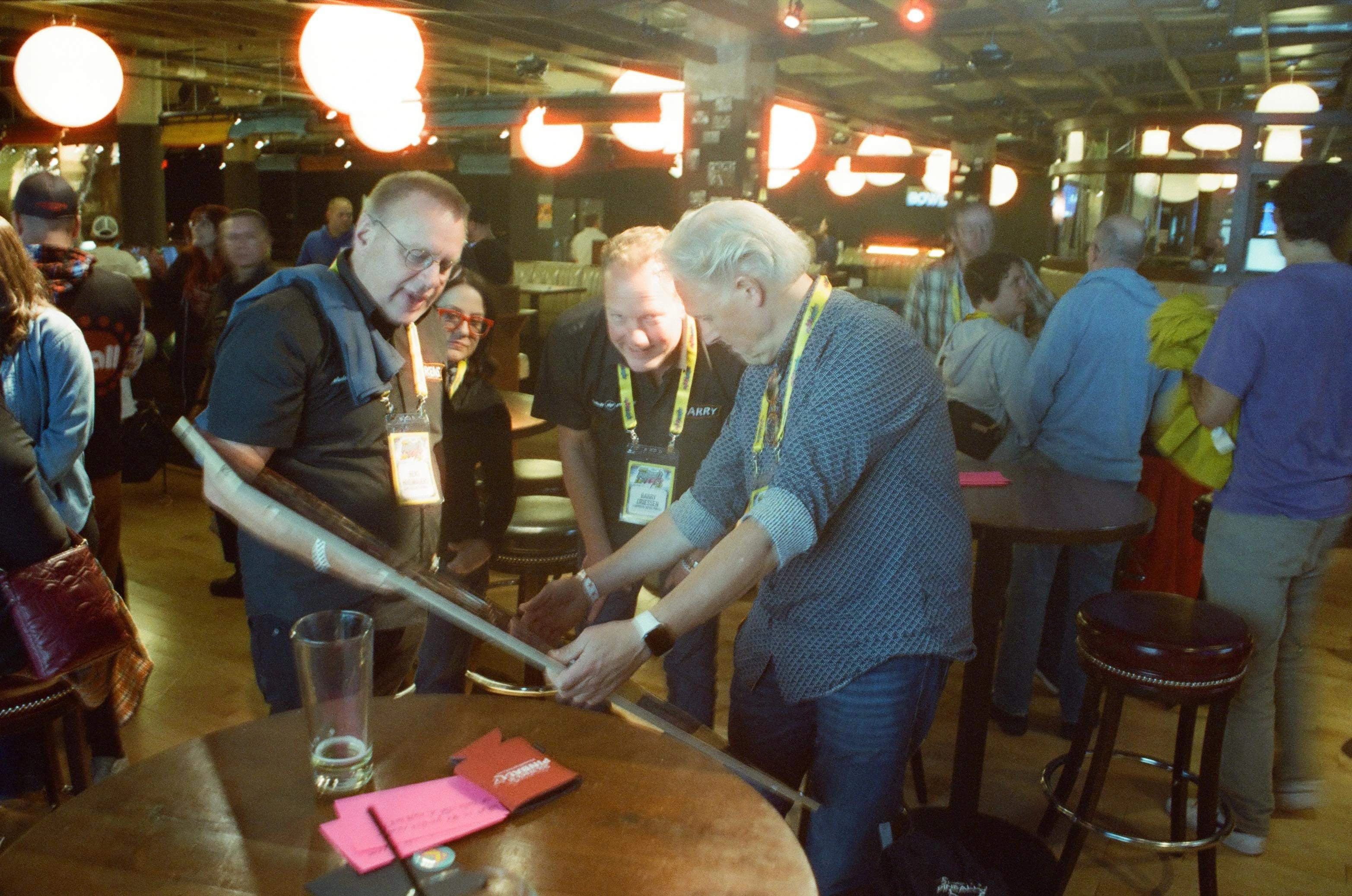 Conference attendees collaborate around table with glowing lanterns overhead