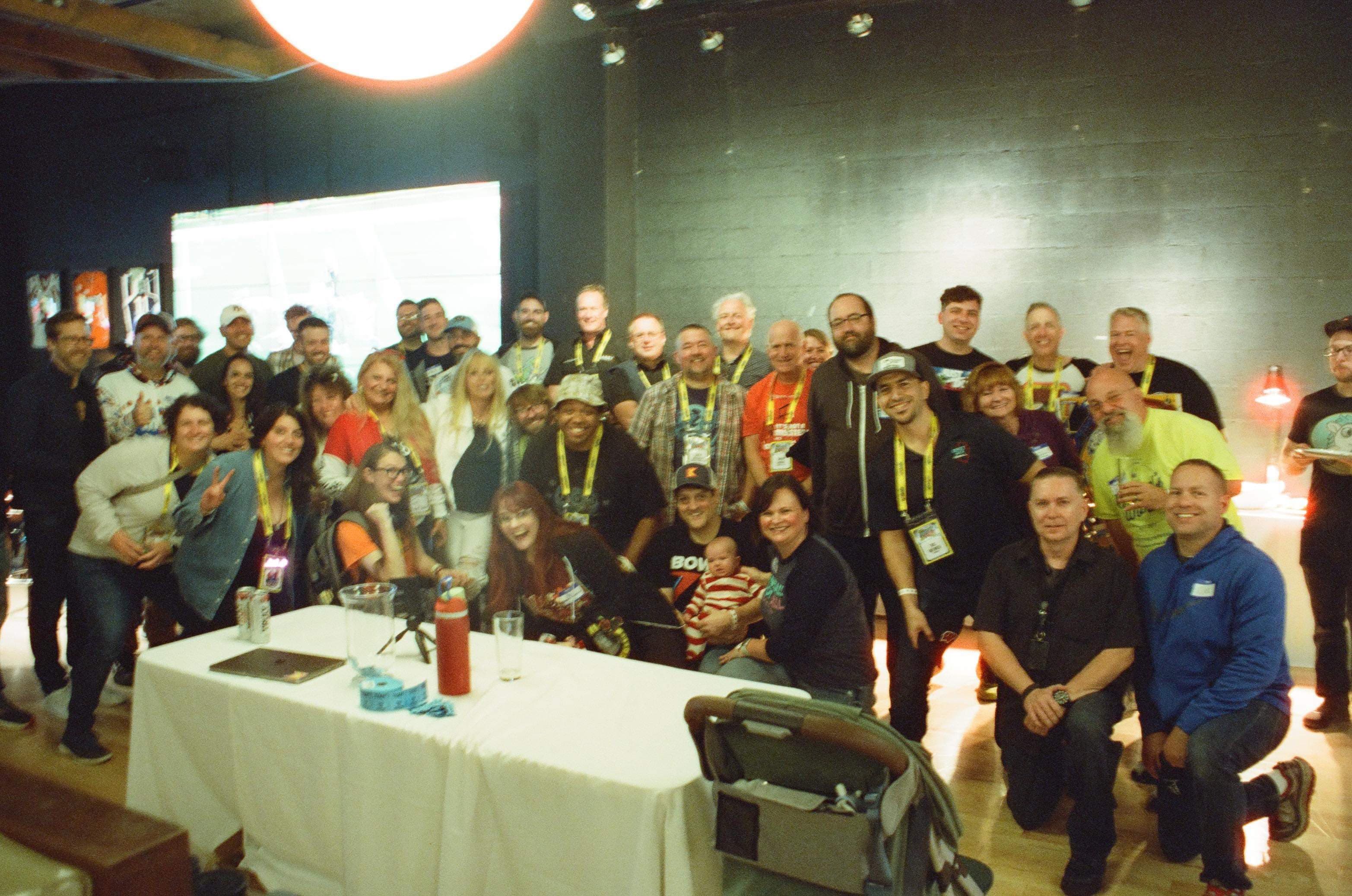 Large group photo of conference attendees with name badges in event space