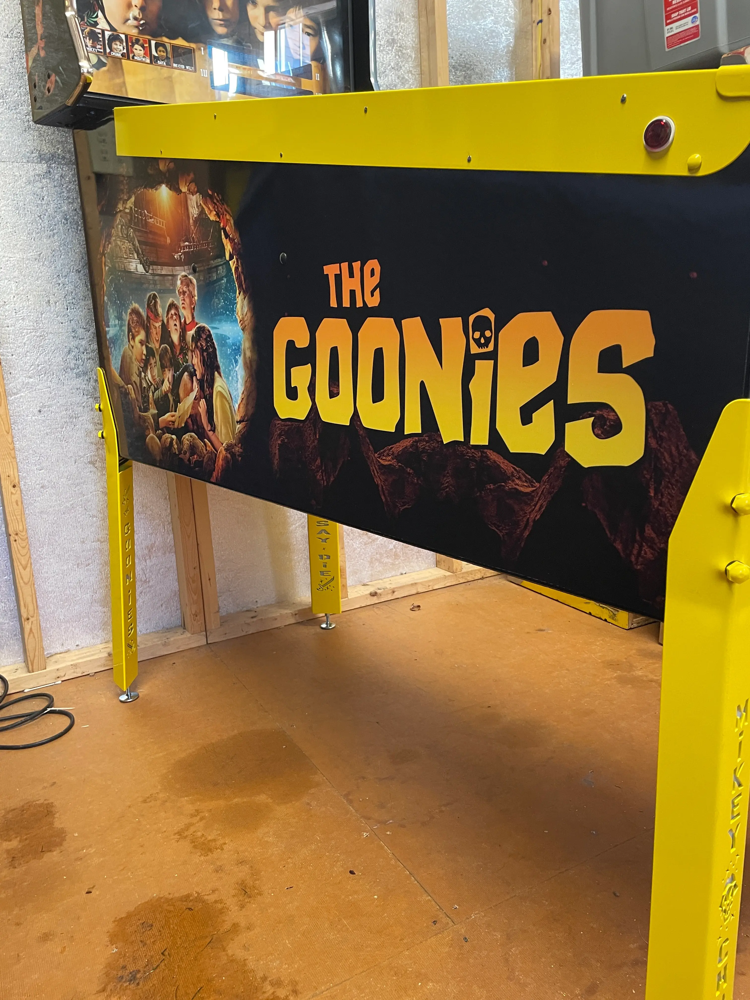 The Goonies movie poster with yellow frame and iconic skull logo