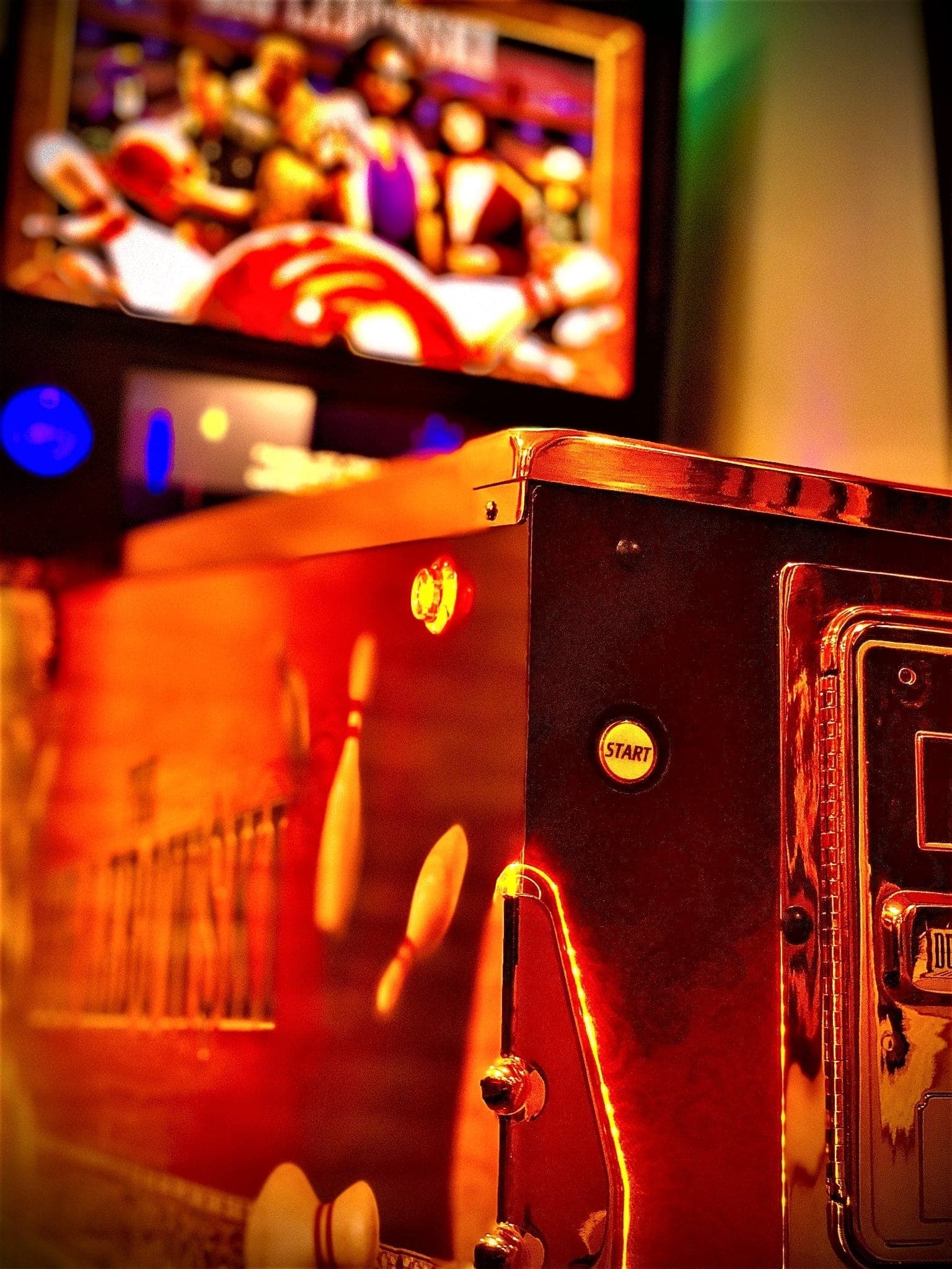 Vintage arcade machine with glowing start button and blurred game screen