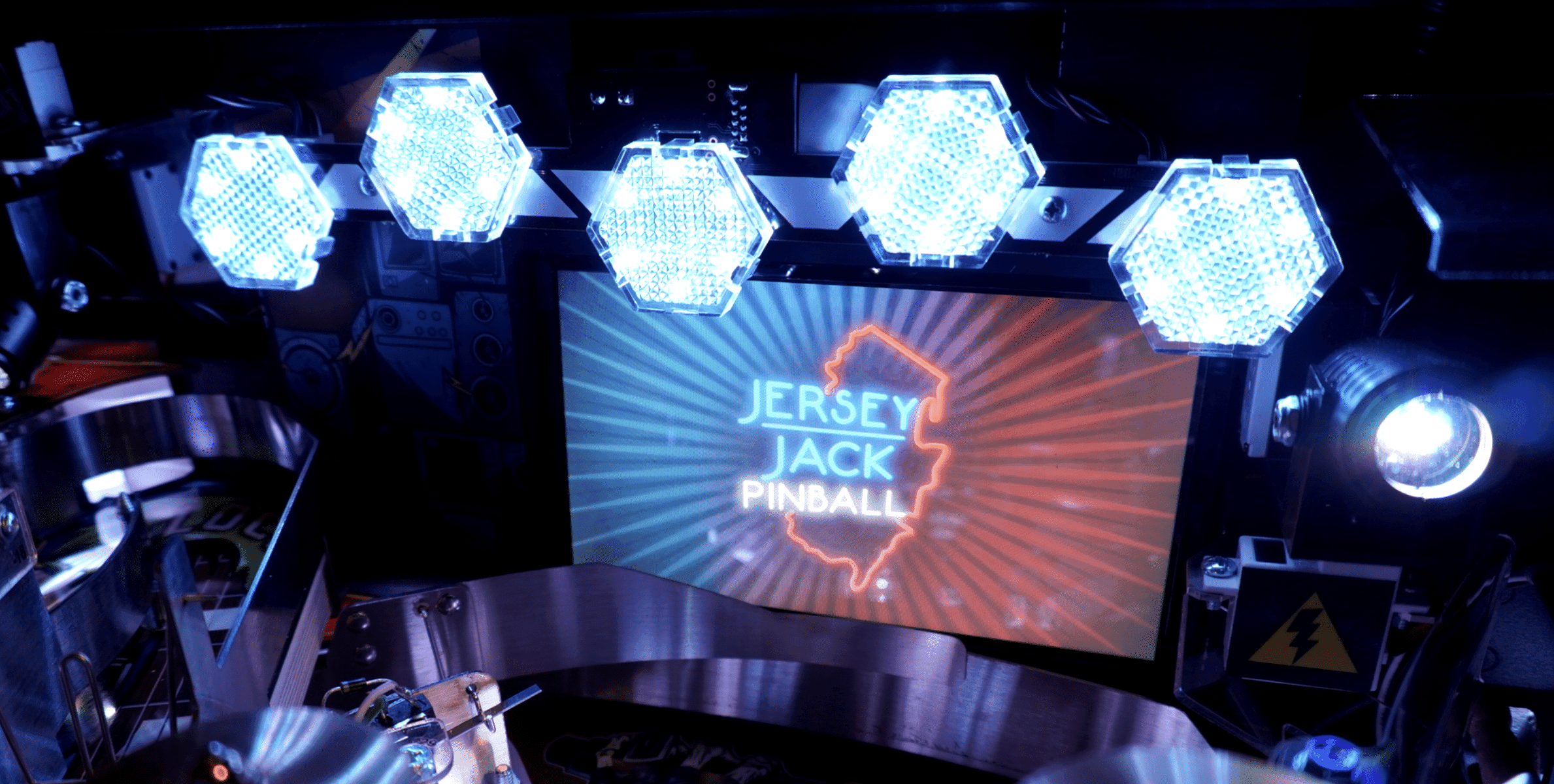 Jersey Jack Pinball machine with glowing hexagonal lights and state logo