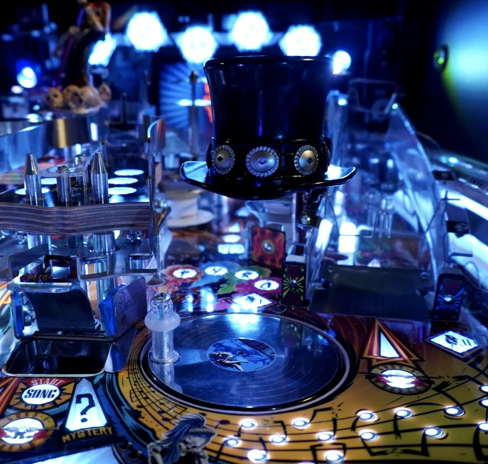 Steampunk-style pinball machine with top hat, glowing lights, and musical theme