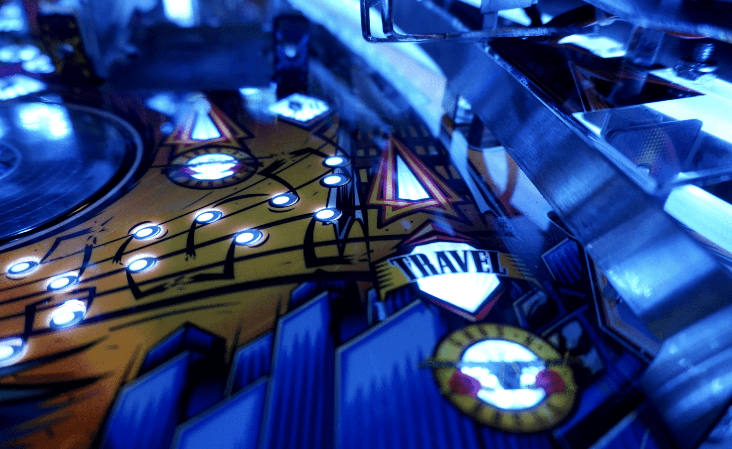 Pinball machine with glowing blue lights and Travel logo