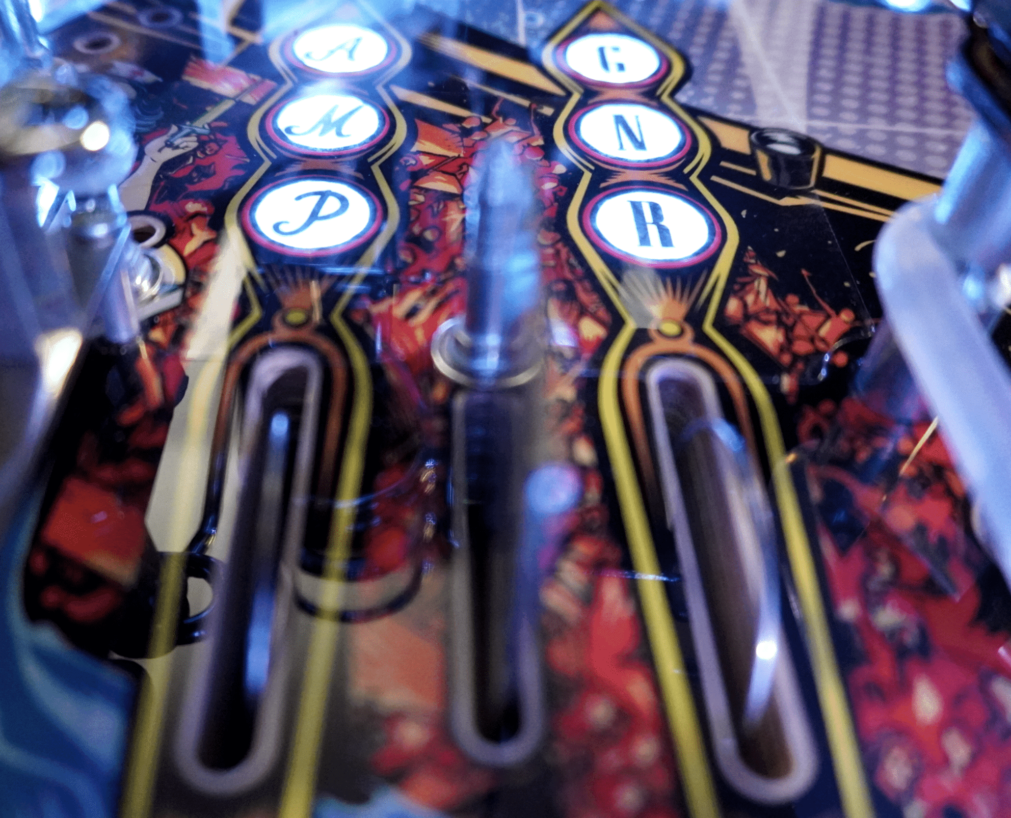 Closeup of pinball machine buttons with illuminated letters