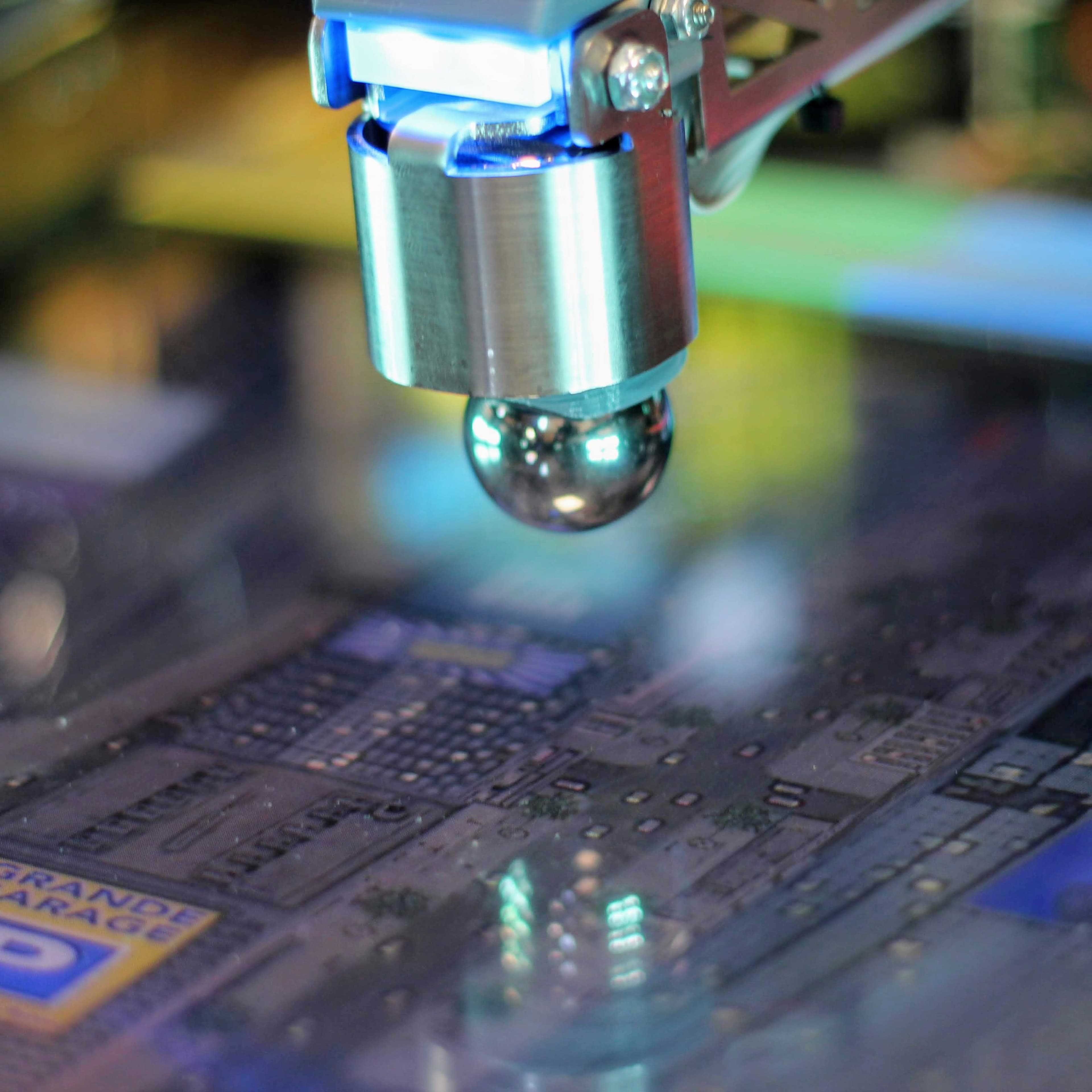 Microscope lens hovering over detailed electronic circuit board