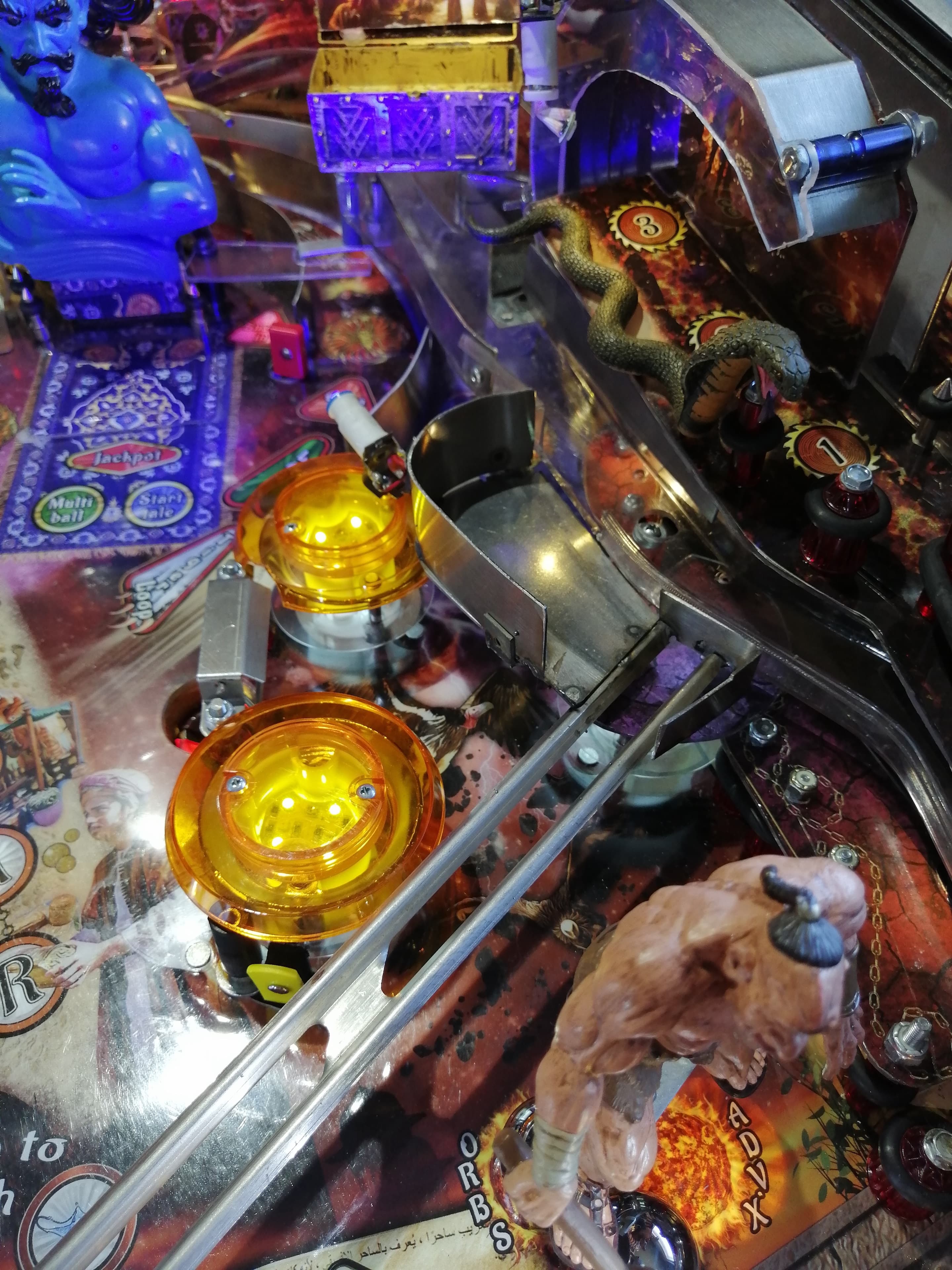 Detailed close-up of a colorful pinball machine with yellow lights