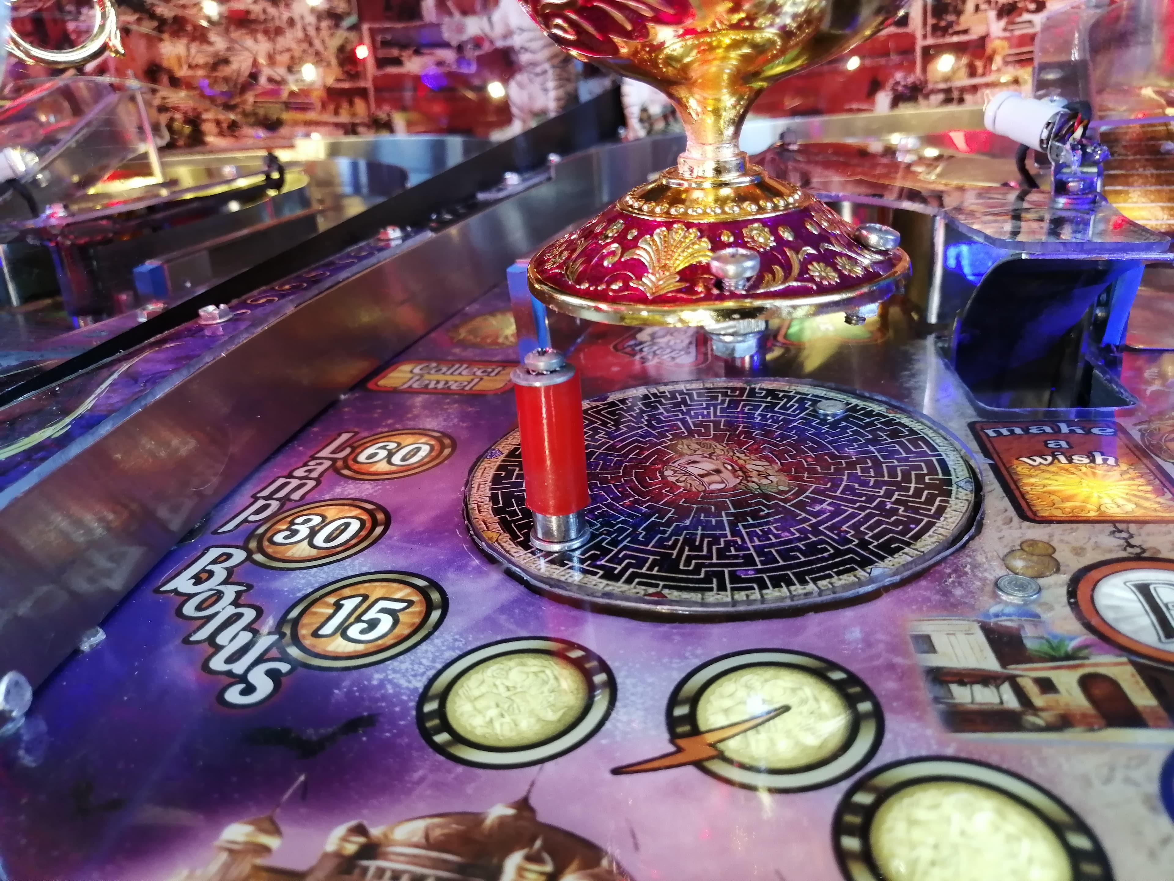 Colorful pinball machine with ornate golden trophy and scoring board