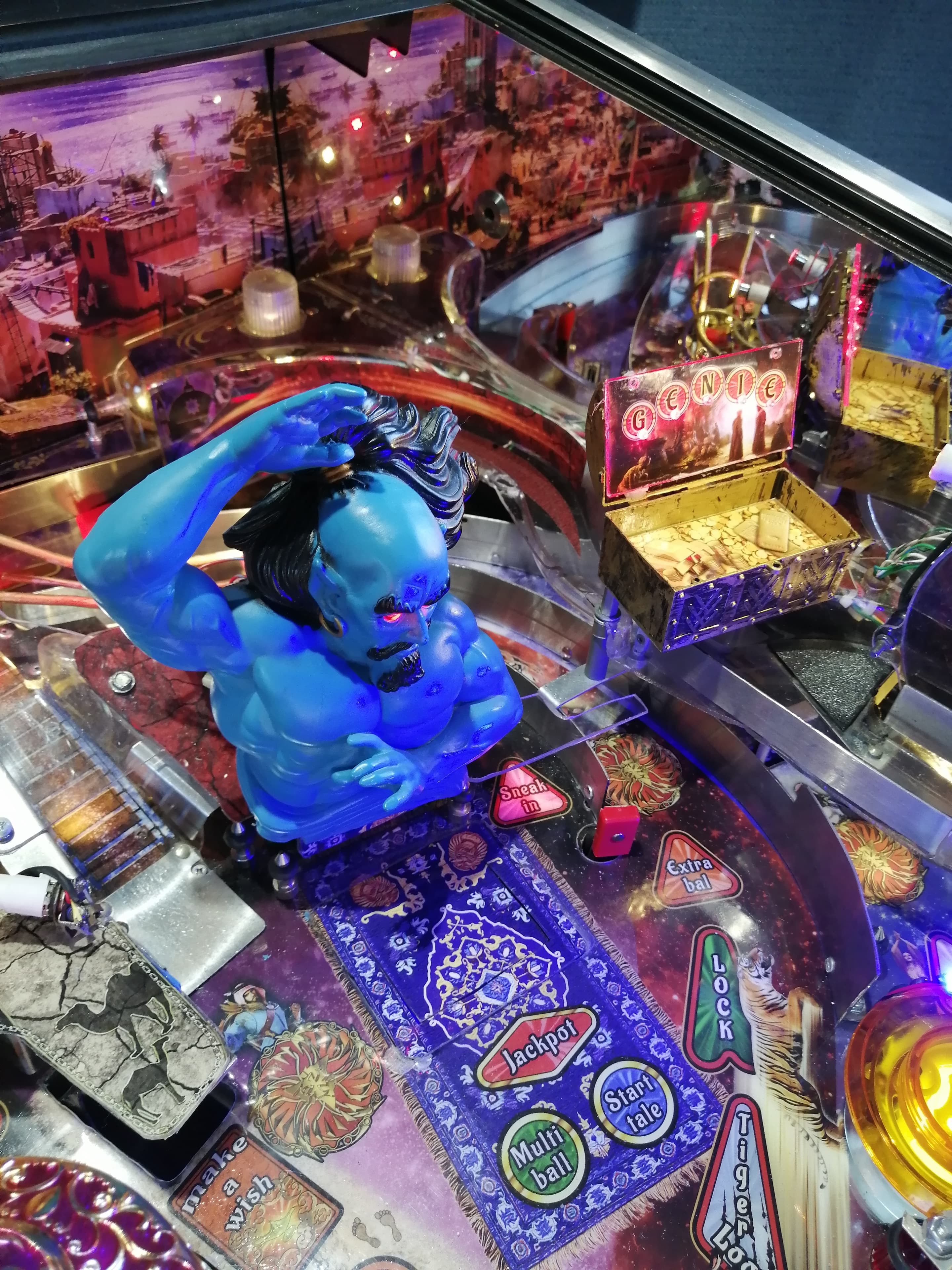Colorful pinball machine with blue genie figure and game elements