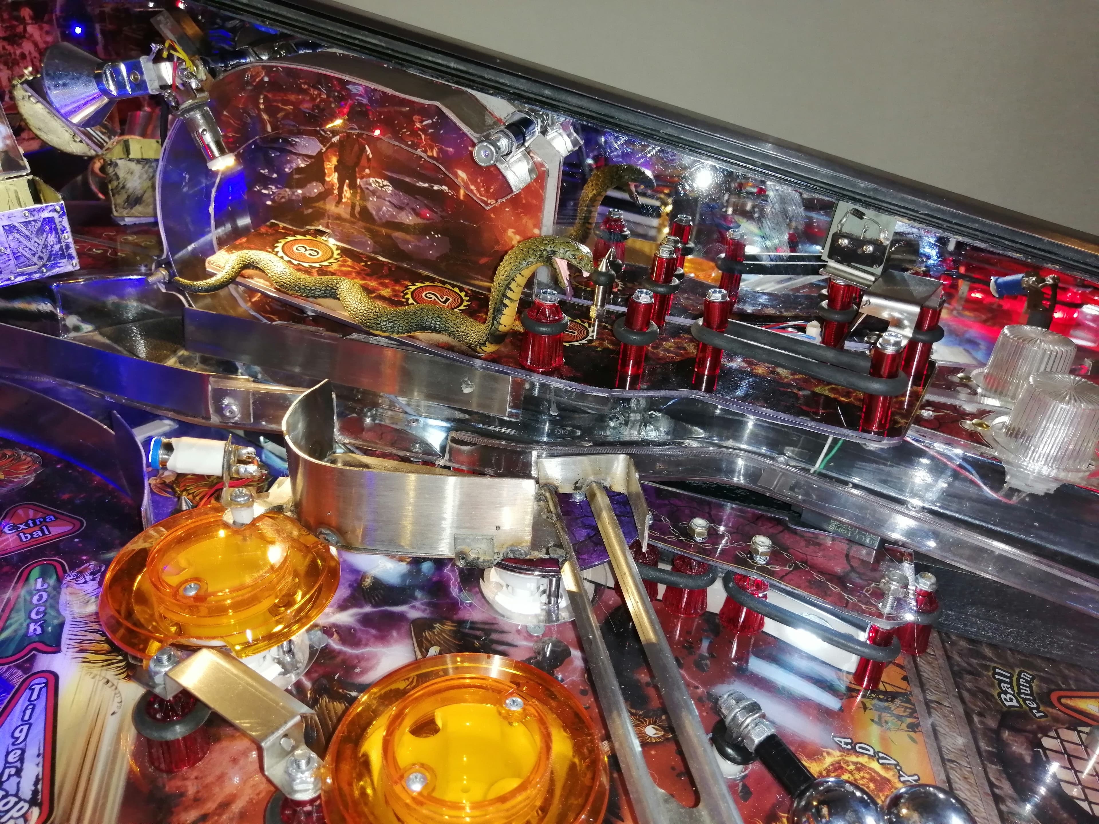 Intricate pinball machine with golden dragon, colorful lights, and mechanical components