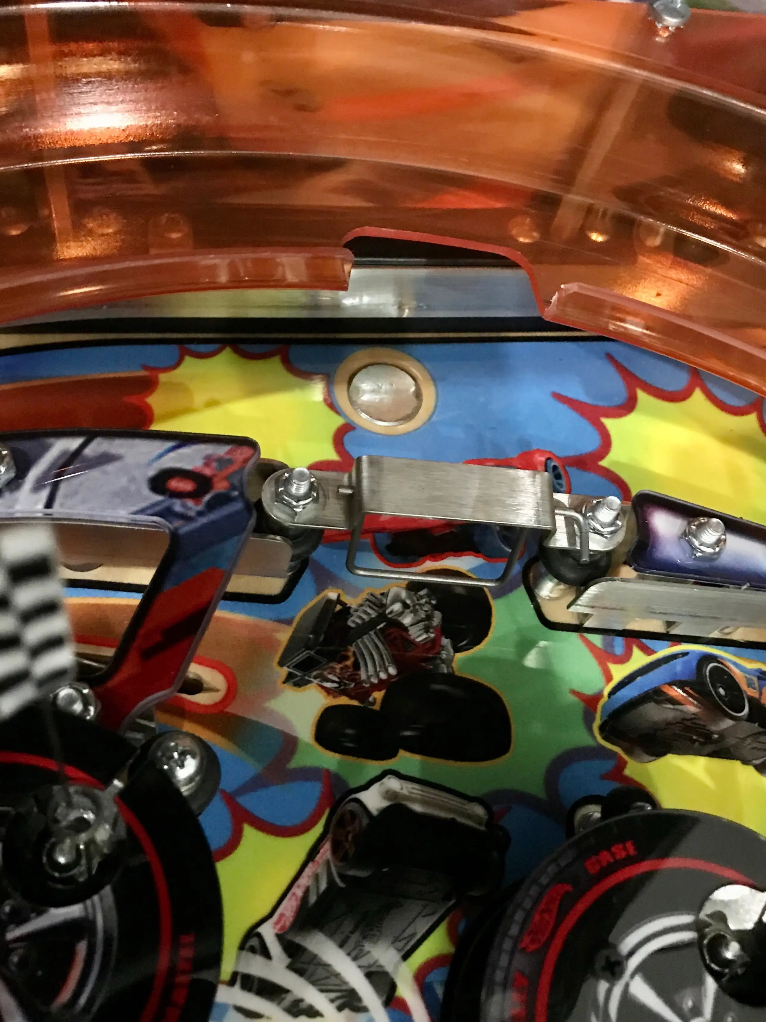 Close-up of colorful pinball machine interior with mechanical components