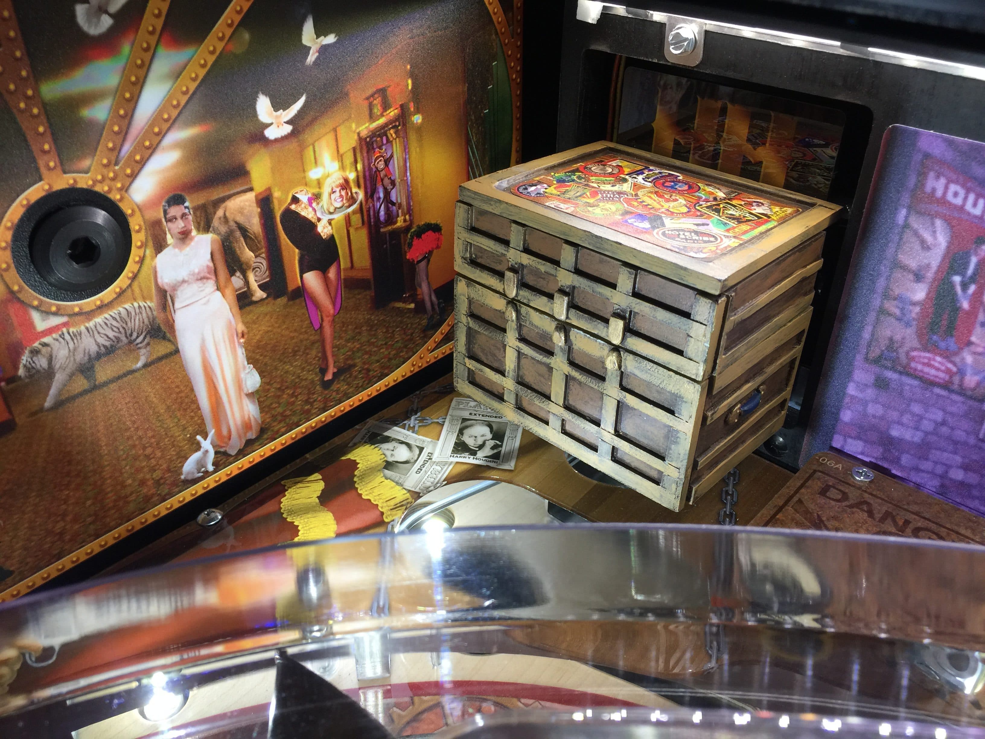 Surreal scene with wooden drawer cabinet, circus-like background, and vintage photos