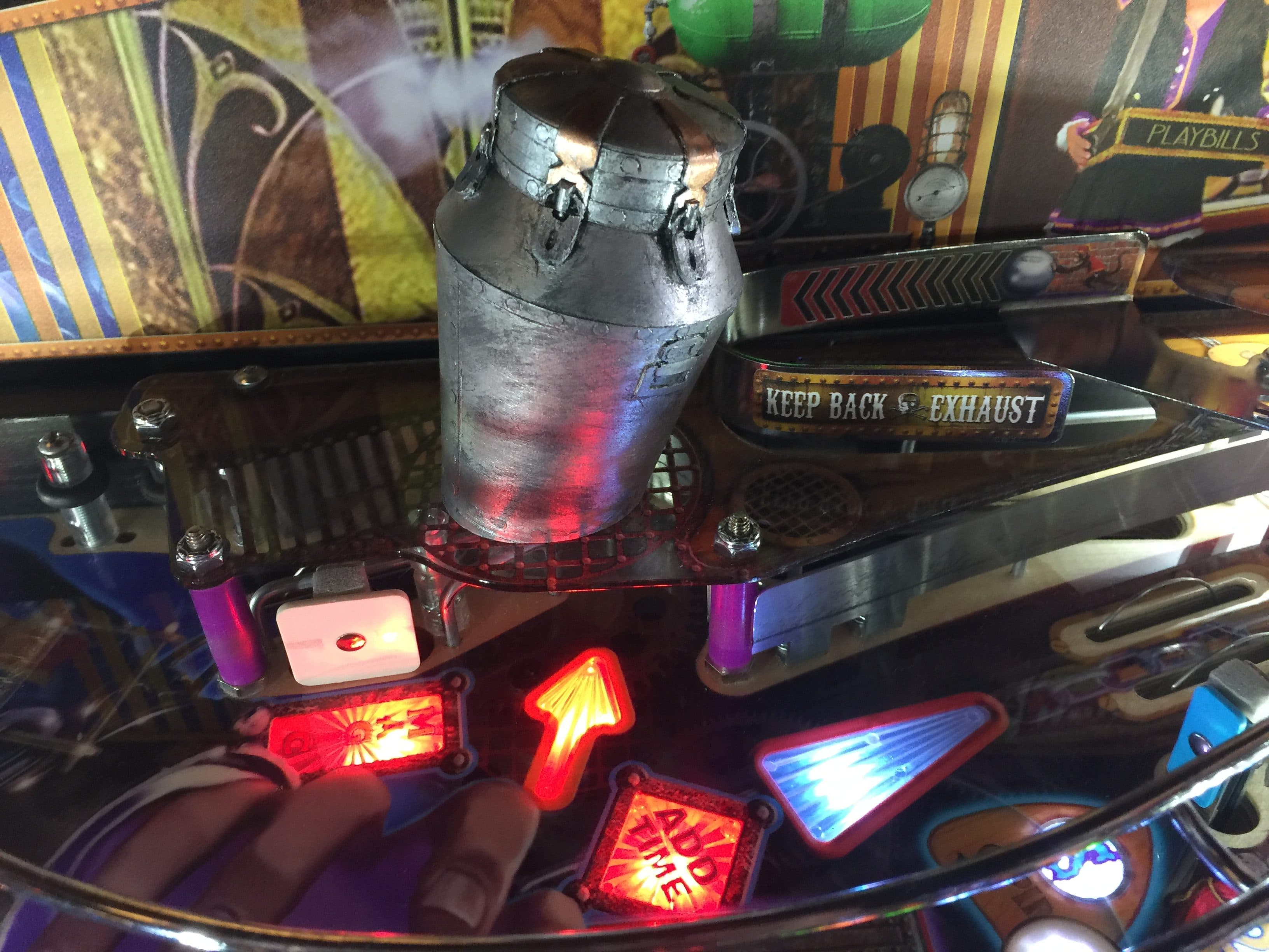 Vintage pinball machine close-up with metallic canister and red lights