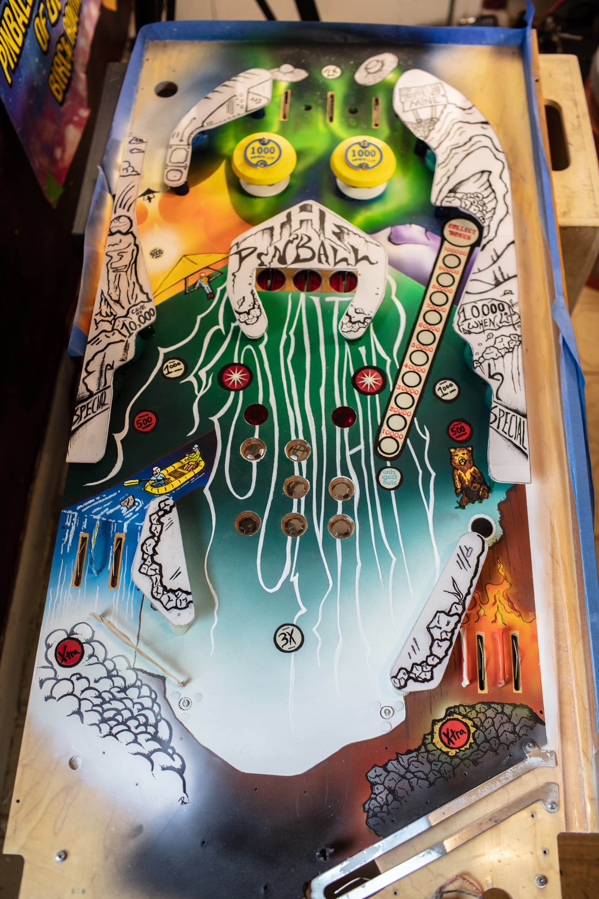 Vintage pinball machine playfield with colorful design and scoring points