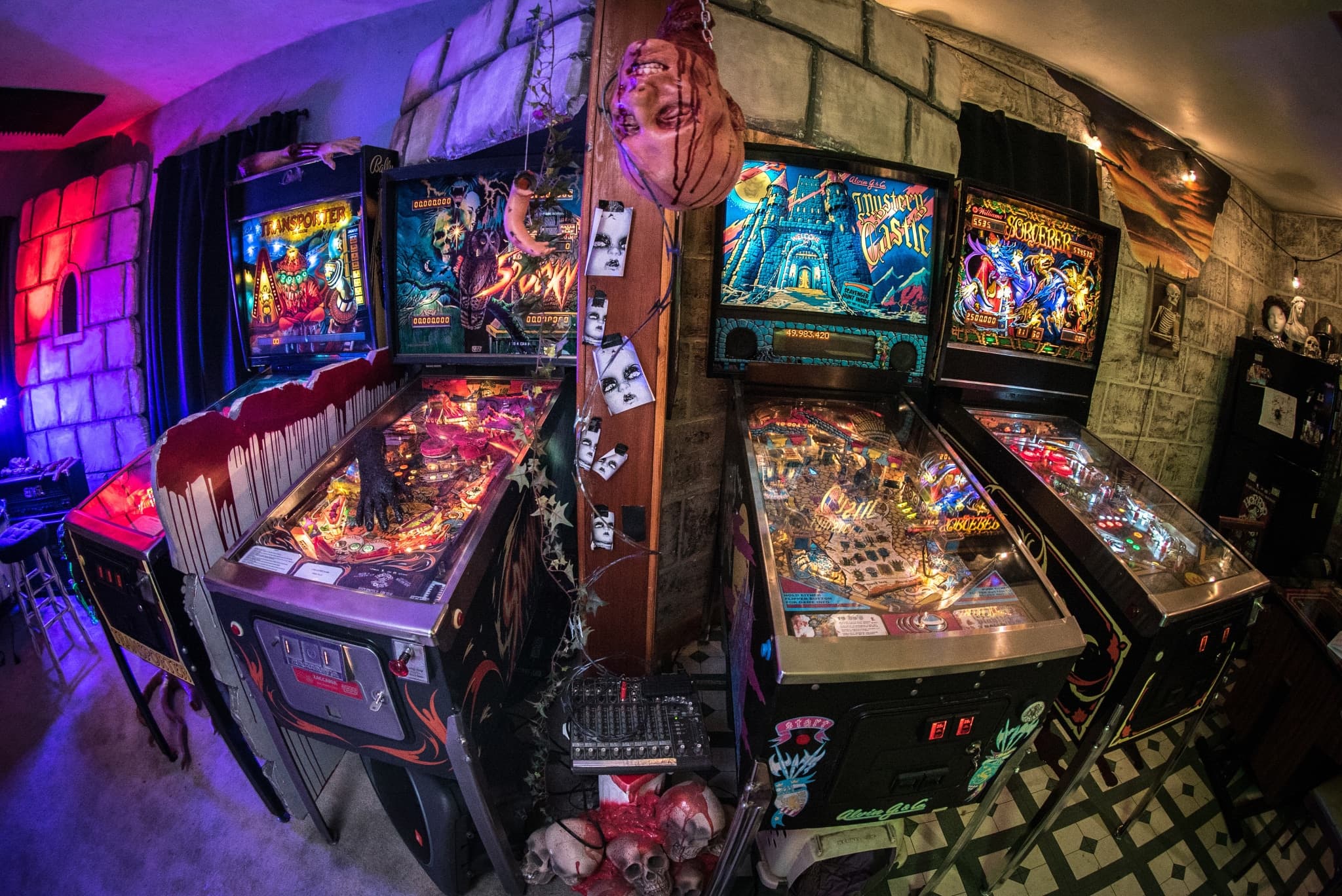 Vintage horror-themed pinball machines in a dimly lit, spooky arcade room