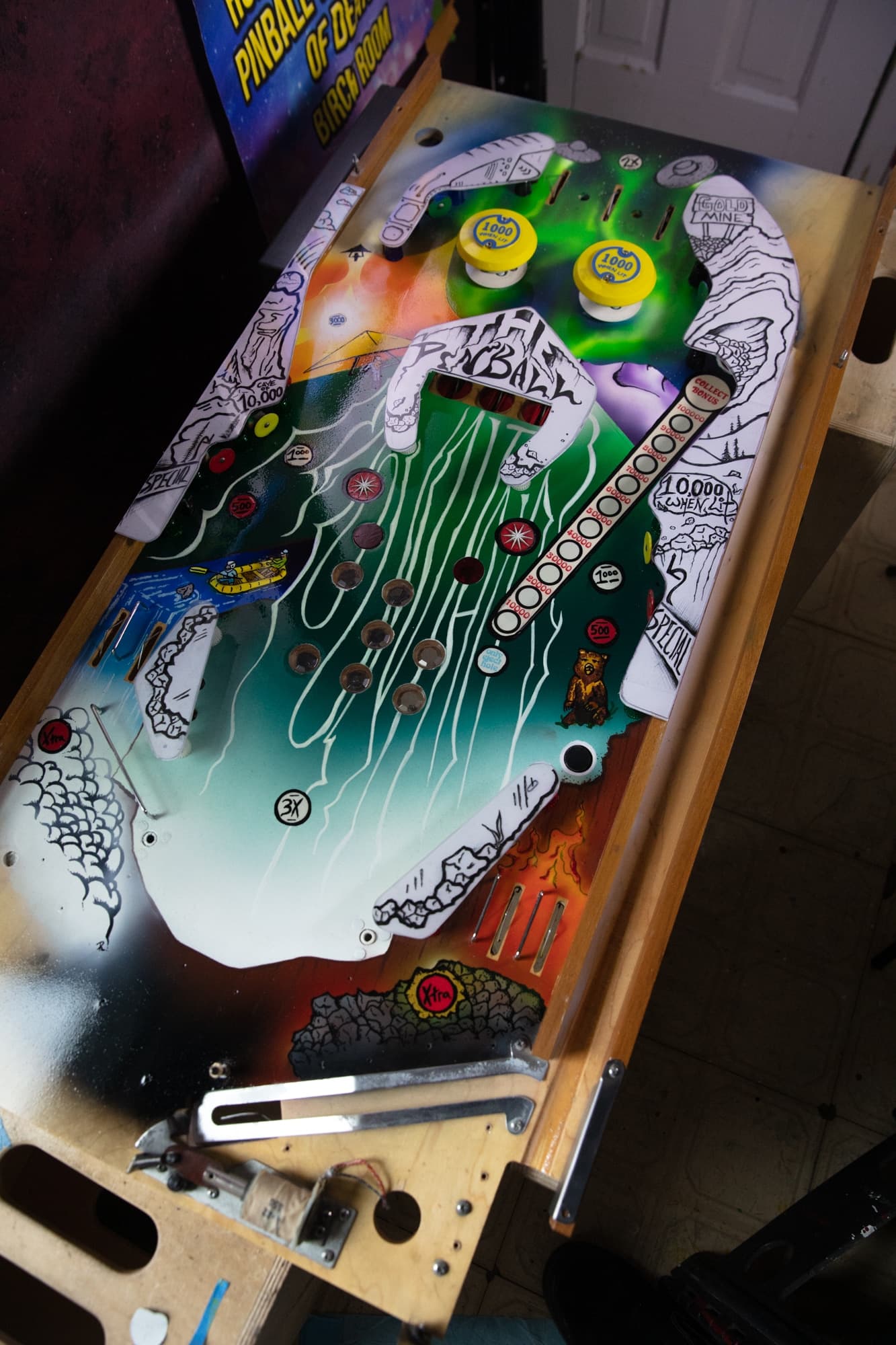 Colorful pinball machine playfield with buttons, ramps, and scoring zones