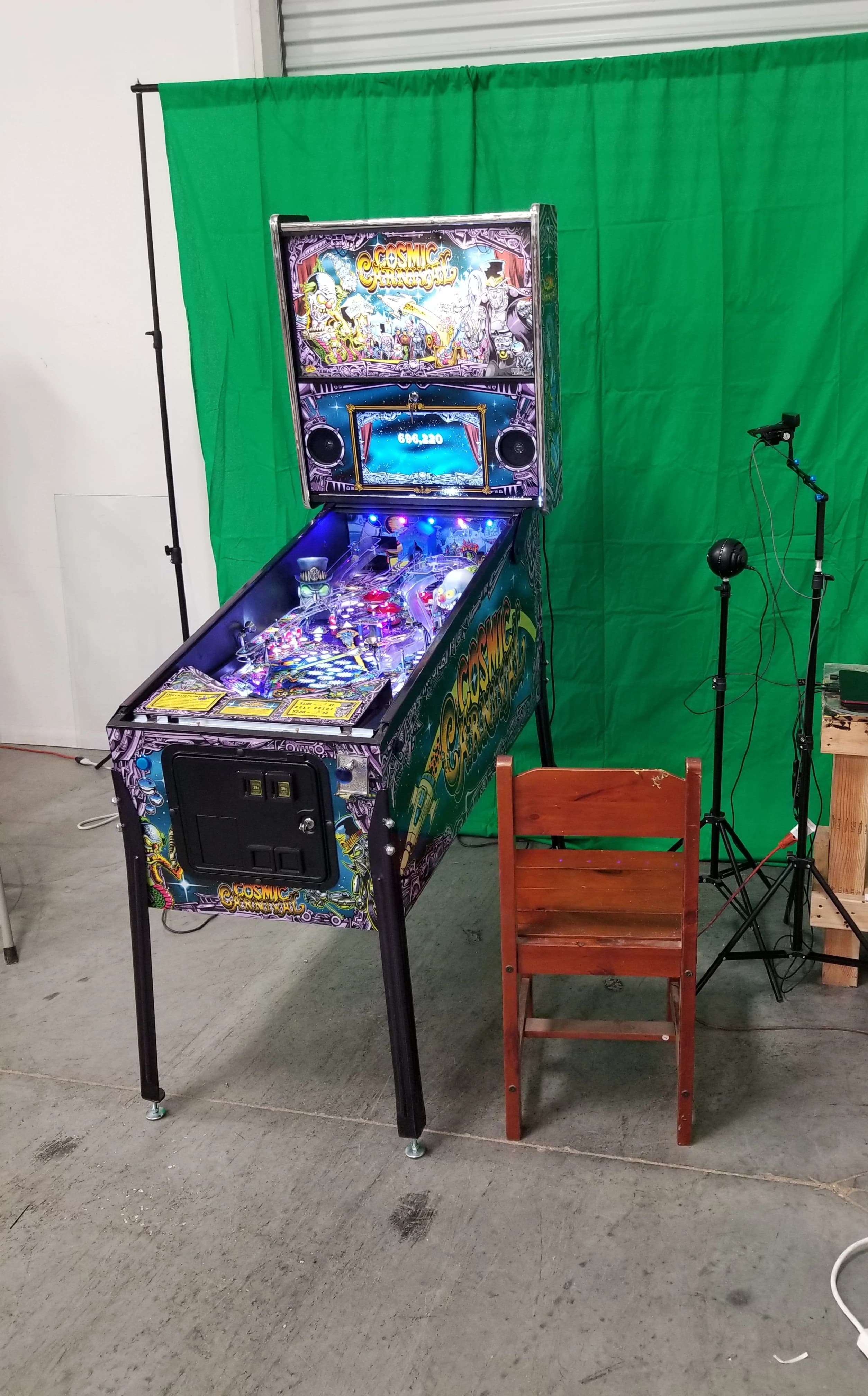 Cosmic-themed pinball machine with colorful playfield and green screen backdrop